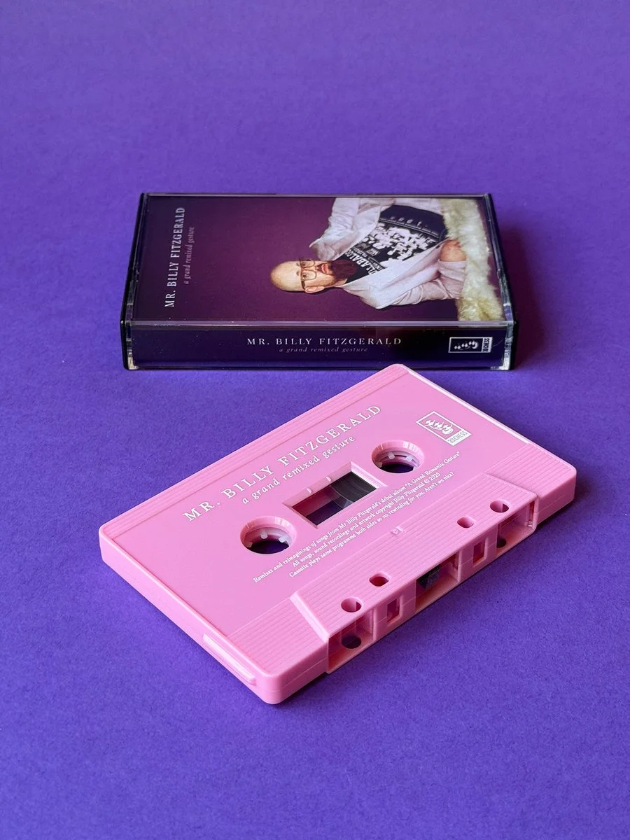 Pink cassette tape titled 'Mr. Billy Fitzgerald' with a film box in the background, featuring an image of a person with glasses resting their head in their hand.