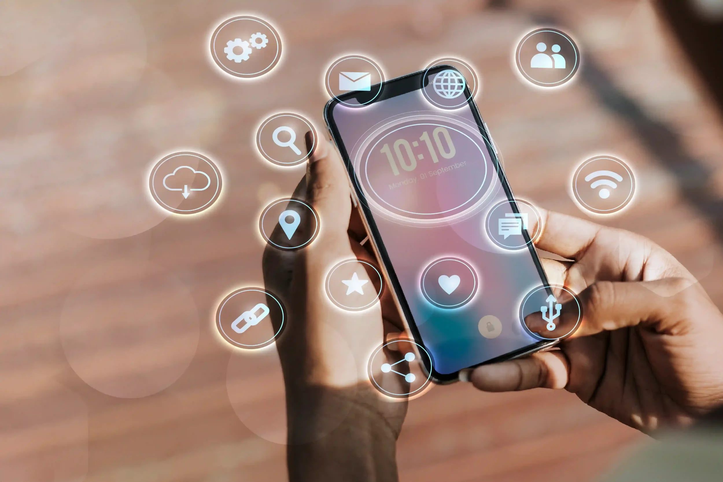A person holding a smartphone with digital holographic icons floating around, including settings, search, cloud download, location, star, Wi-Fi, messaging, heart, USB, share, chain link, and gear icons.