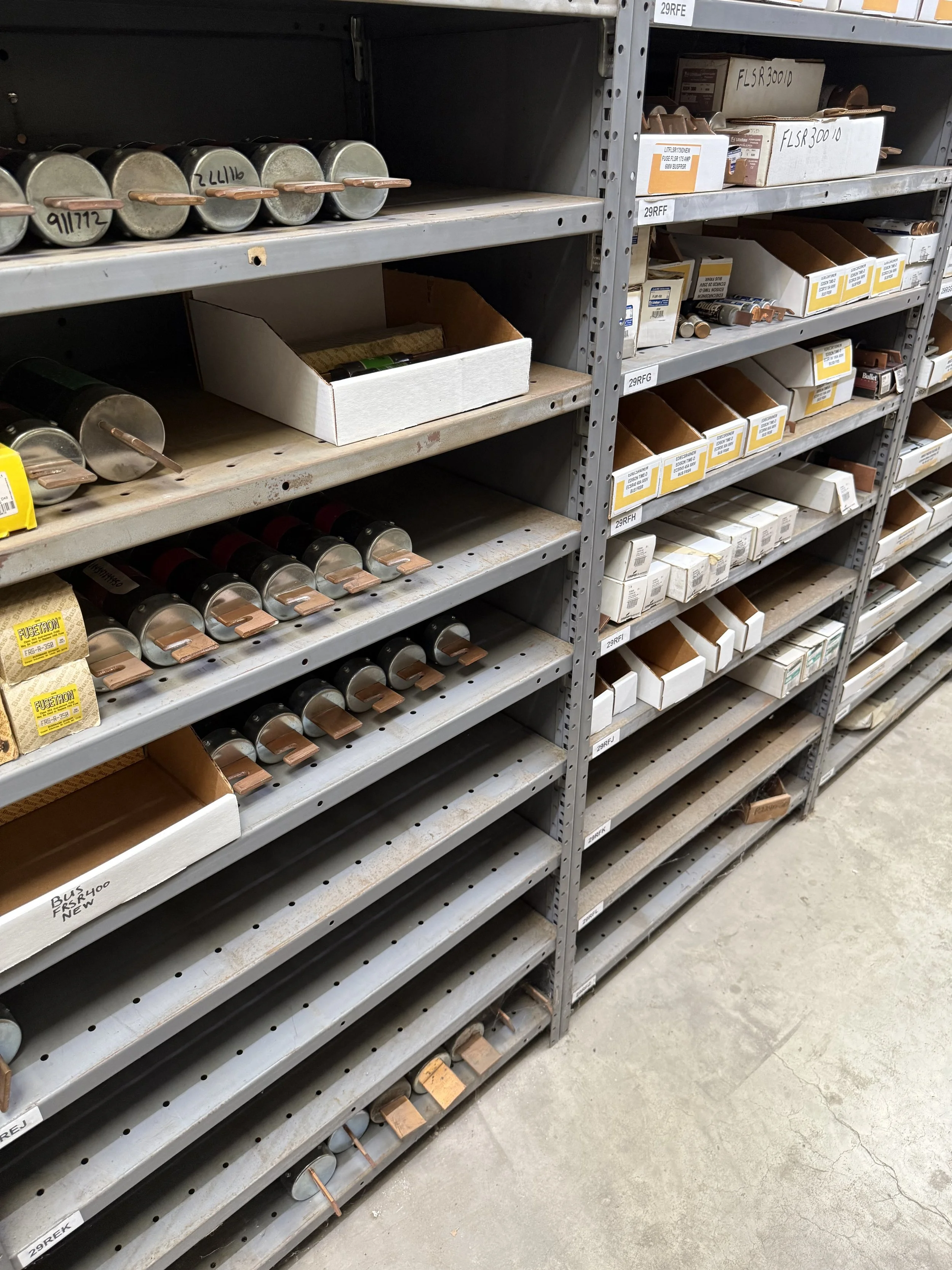 Various electrical parts, including fuses, relays, breakers and other components, some in boxes and some loose.