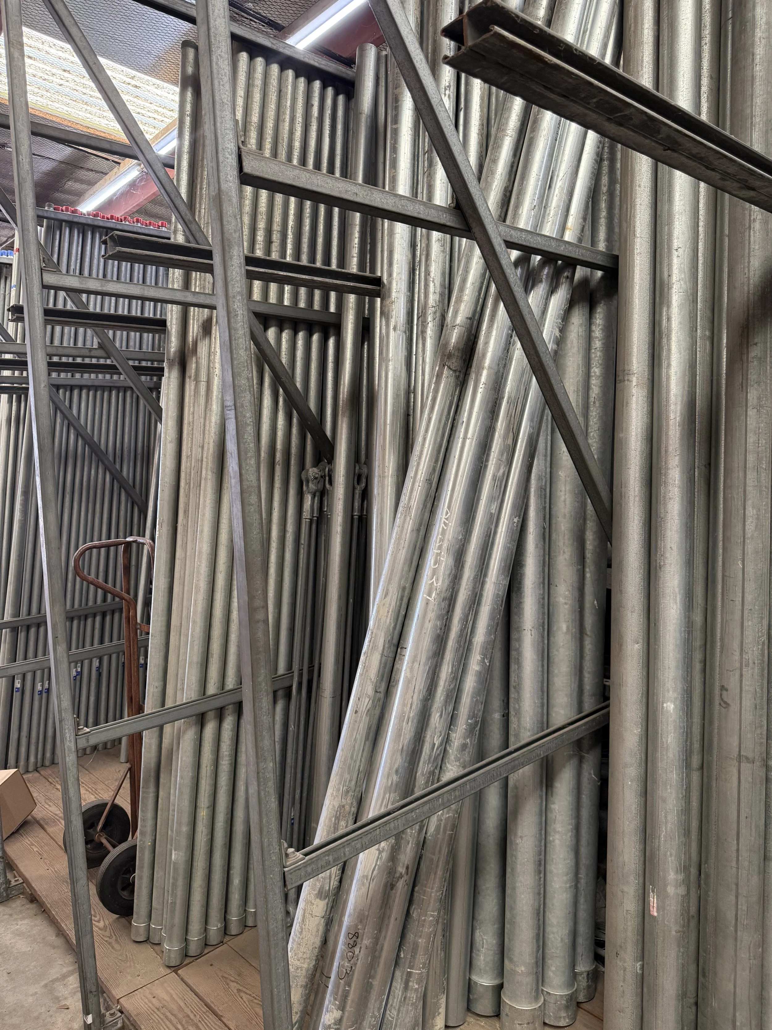 A collection of conduit stacked together in a storage area.