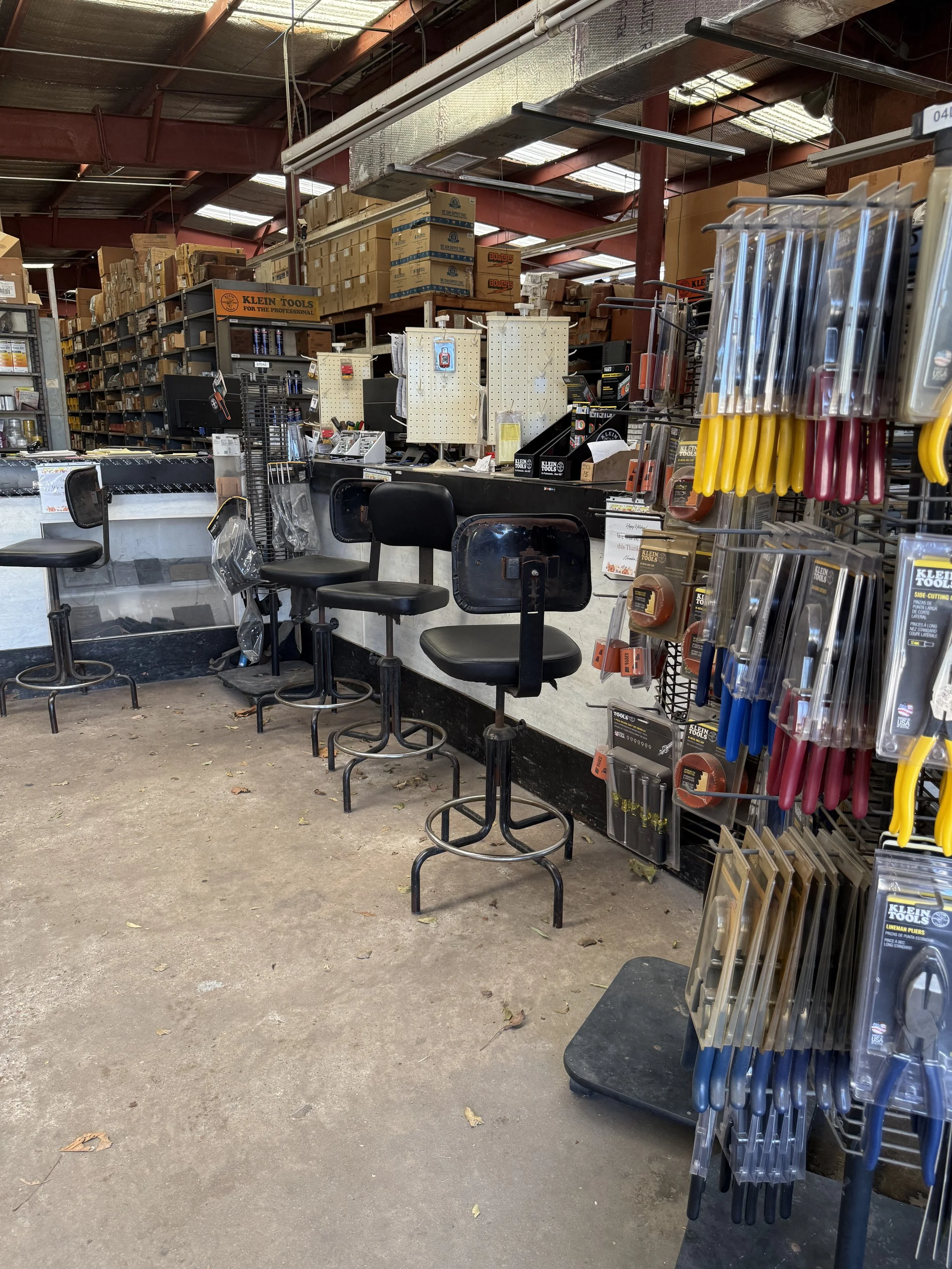 Store aisle with bar stools, hand tools, and hardware for sale. Klien