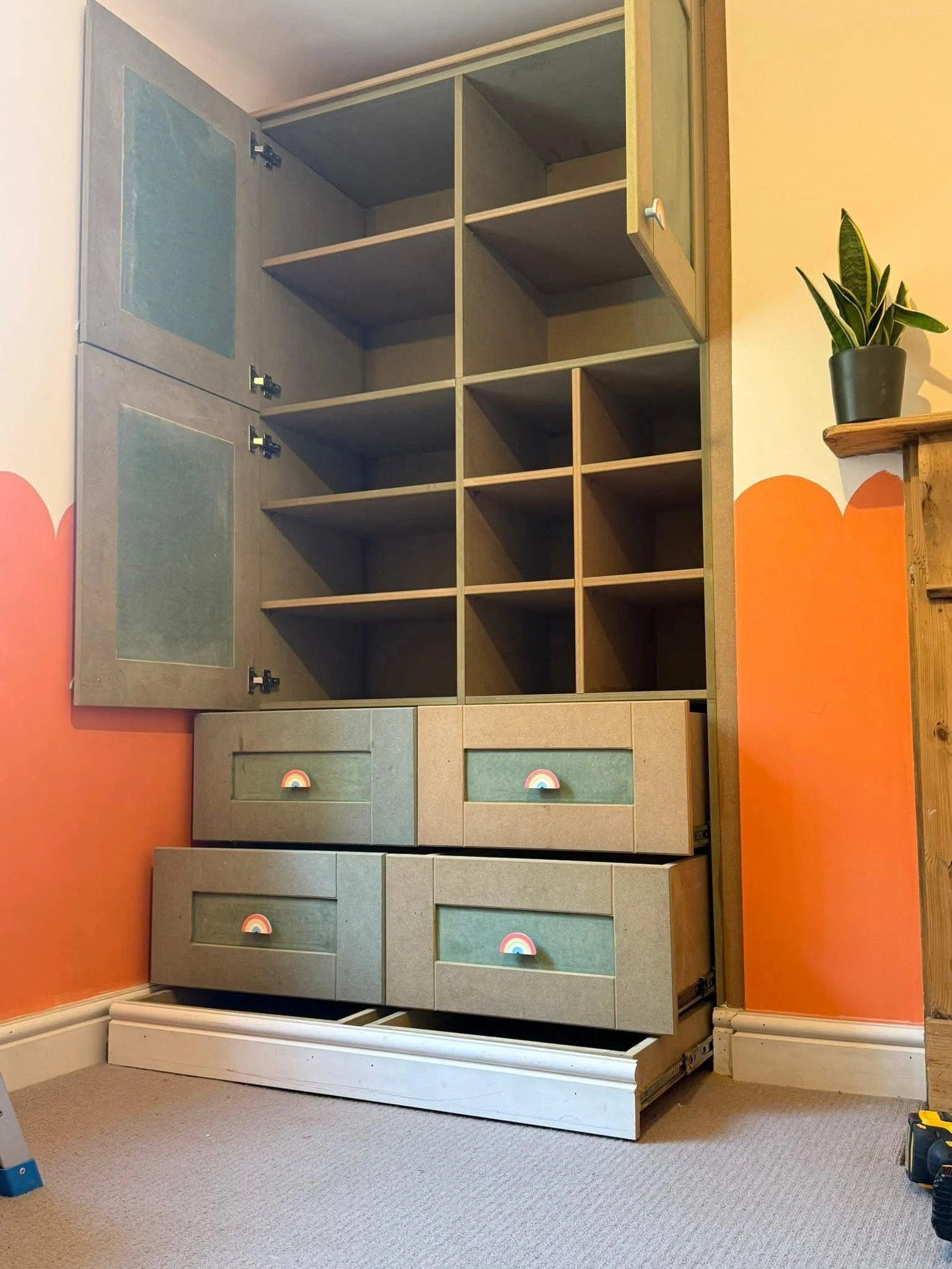 Fitted green cabinet with glazed doors and open shelving
