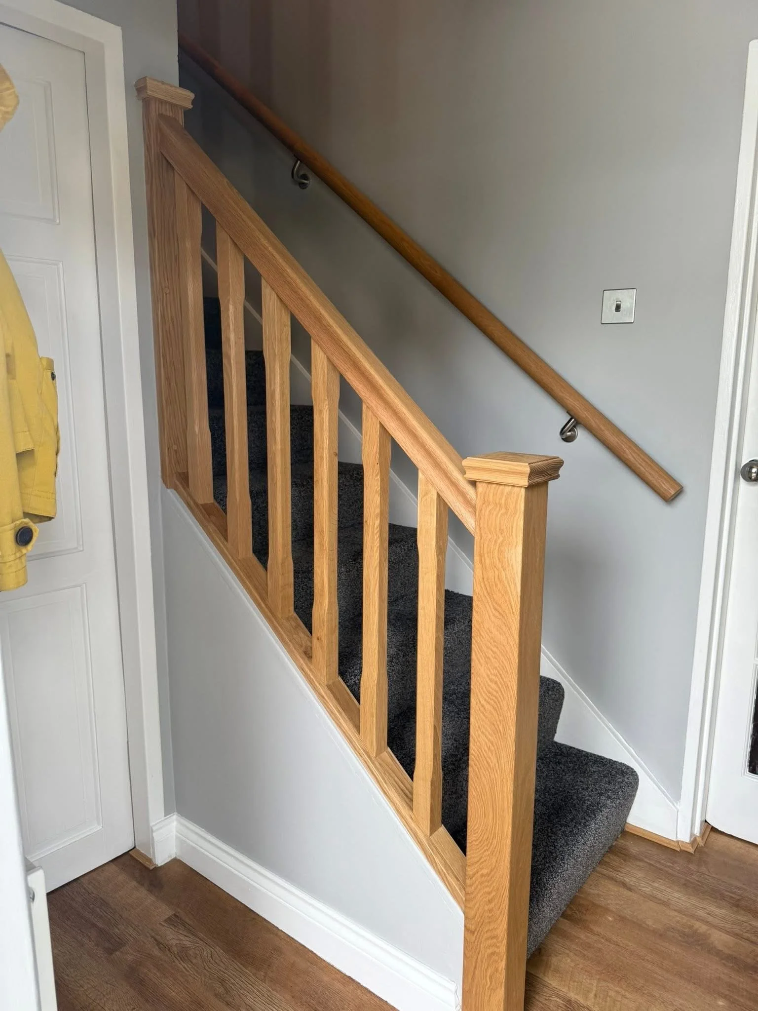 Oak staircase balustrade with wall-mounted handrail