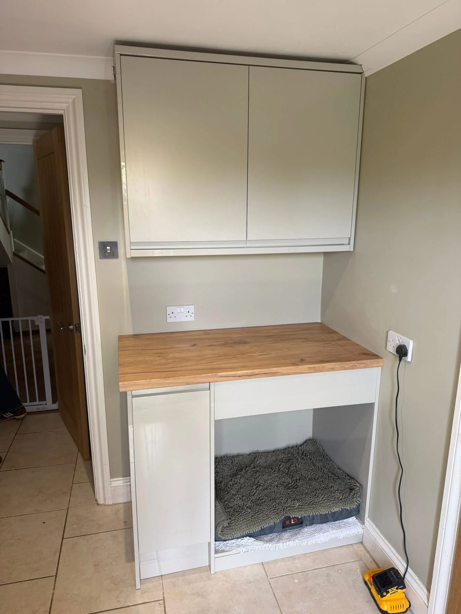 Built-in utility nook with wooden worktop and a dog bed underneath