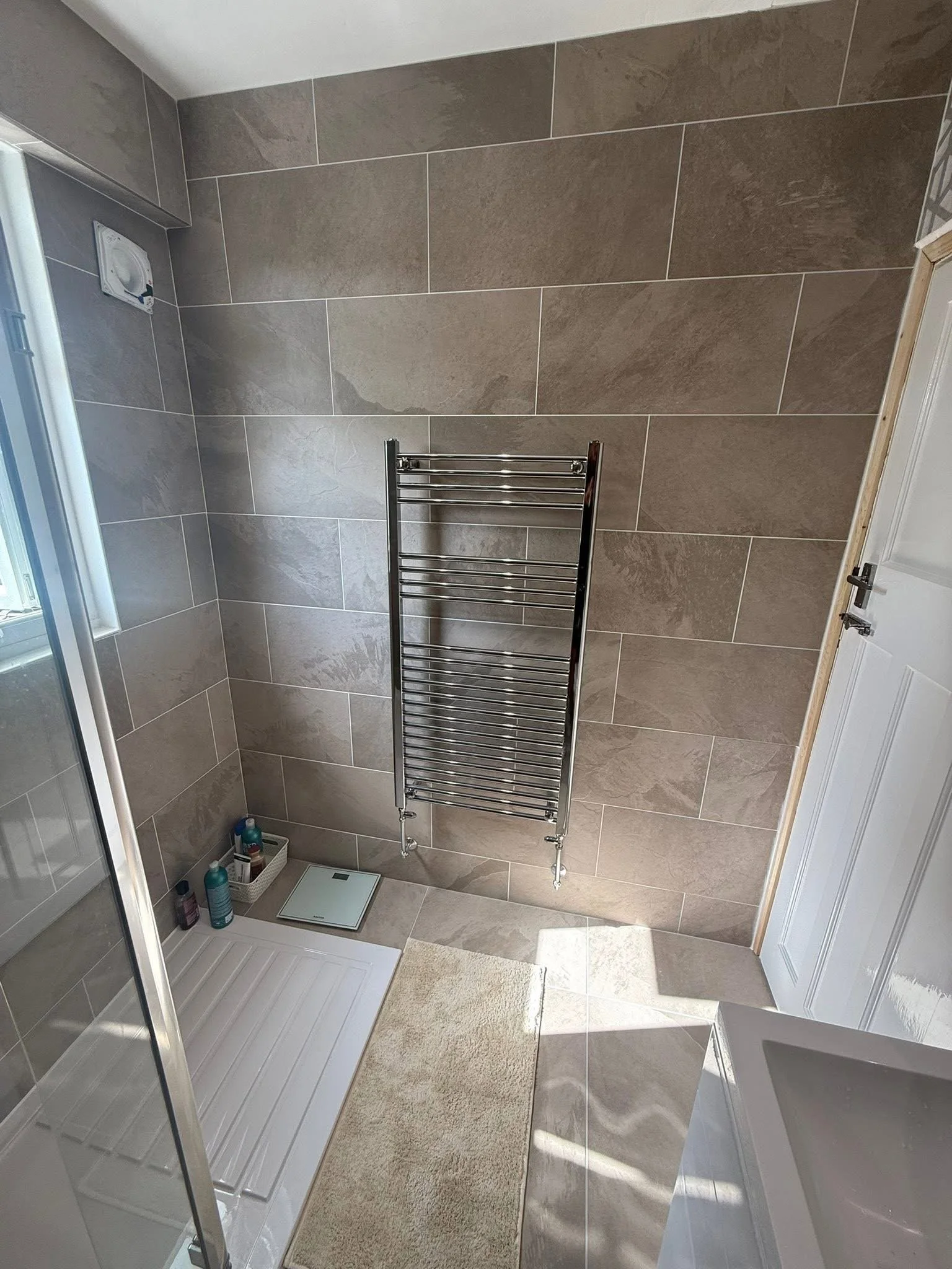 Bathroom renovation with full-height tiling and heated towel rail in Tavistock