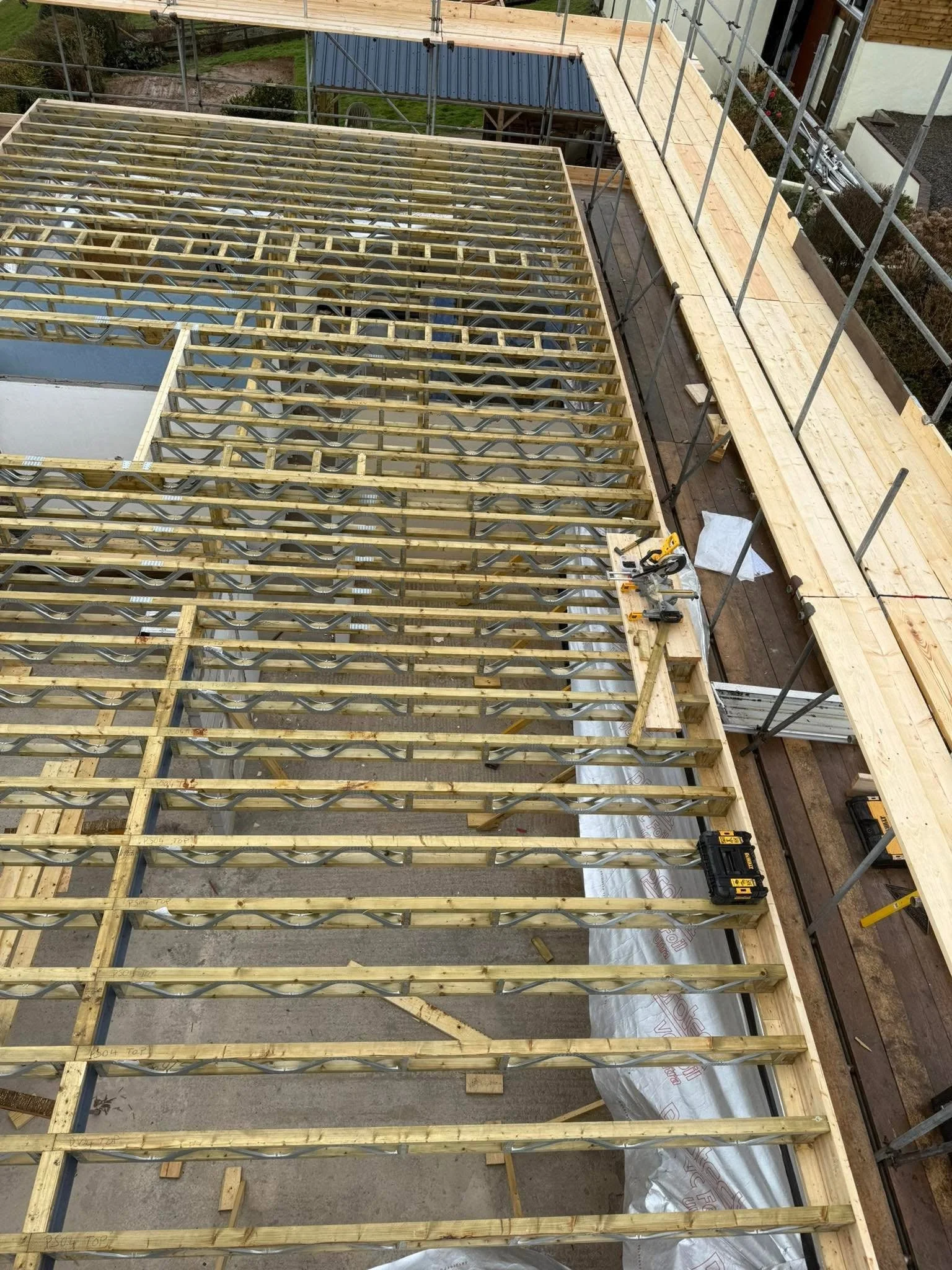 Floor and roof joists laid out on a timber-frame build