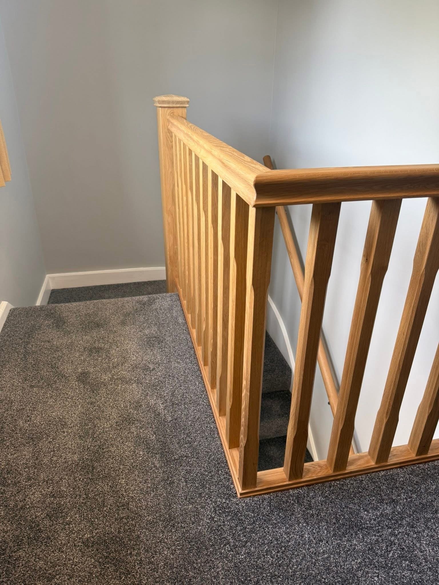 Oak spindles and handrail on a landing balustrade