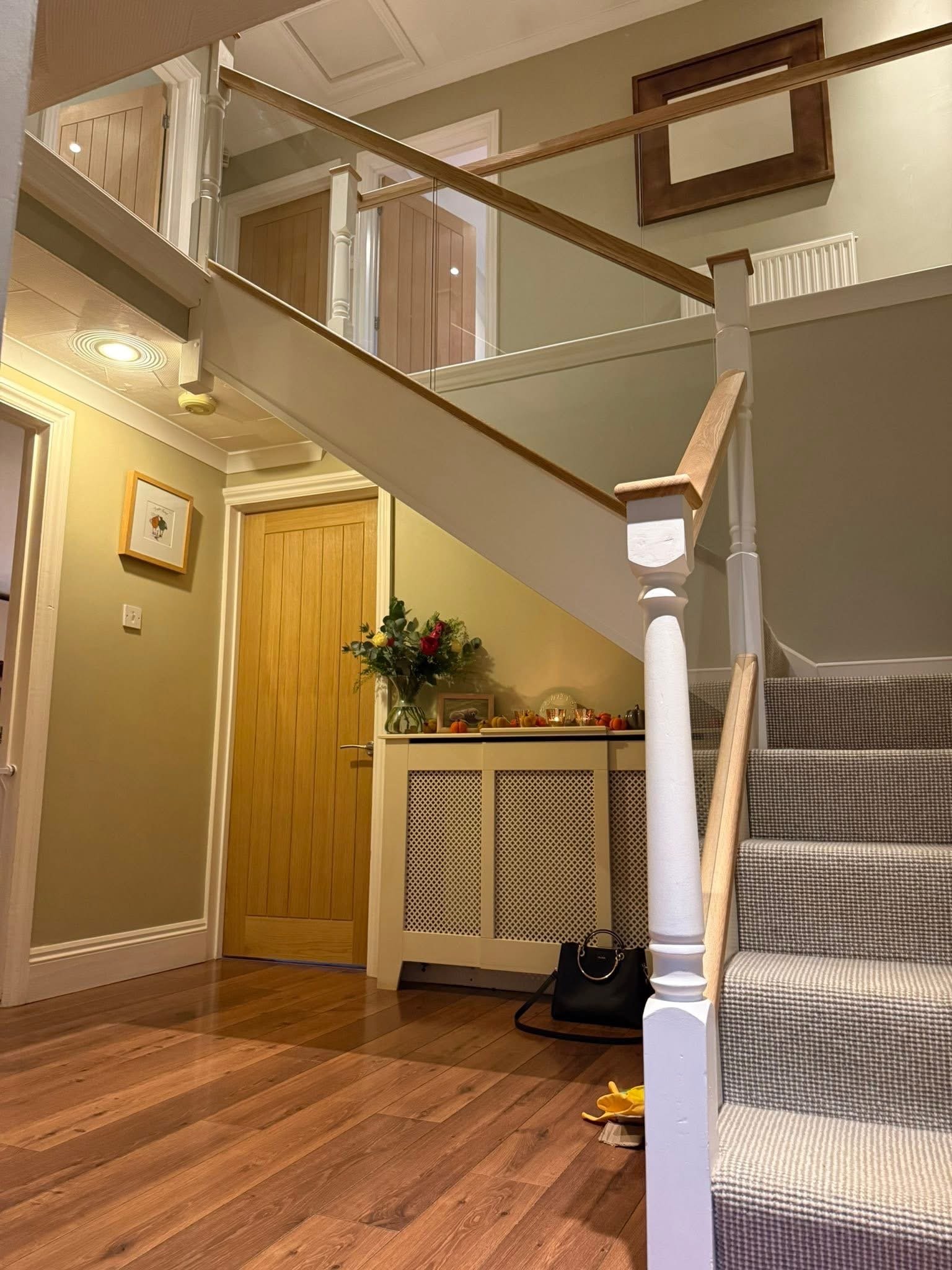 Staircase with glass balustrade, oak handrail and white newel posts