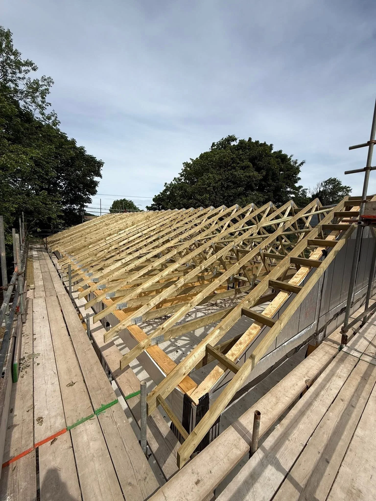Pitched roof trusses being installed on an extension