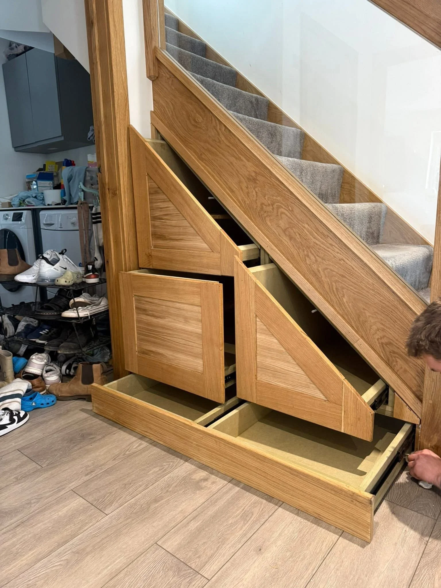 Oak pull-out storage drawers fitted under a staircase