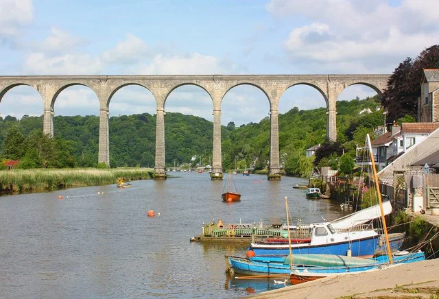Calstock Viaduct crossing the River Tamar, with the picturesque Cornish village of Calstock and wooded hills in the background.