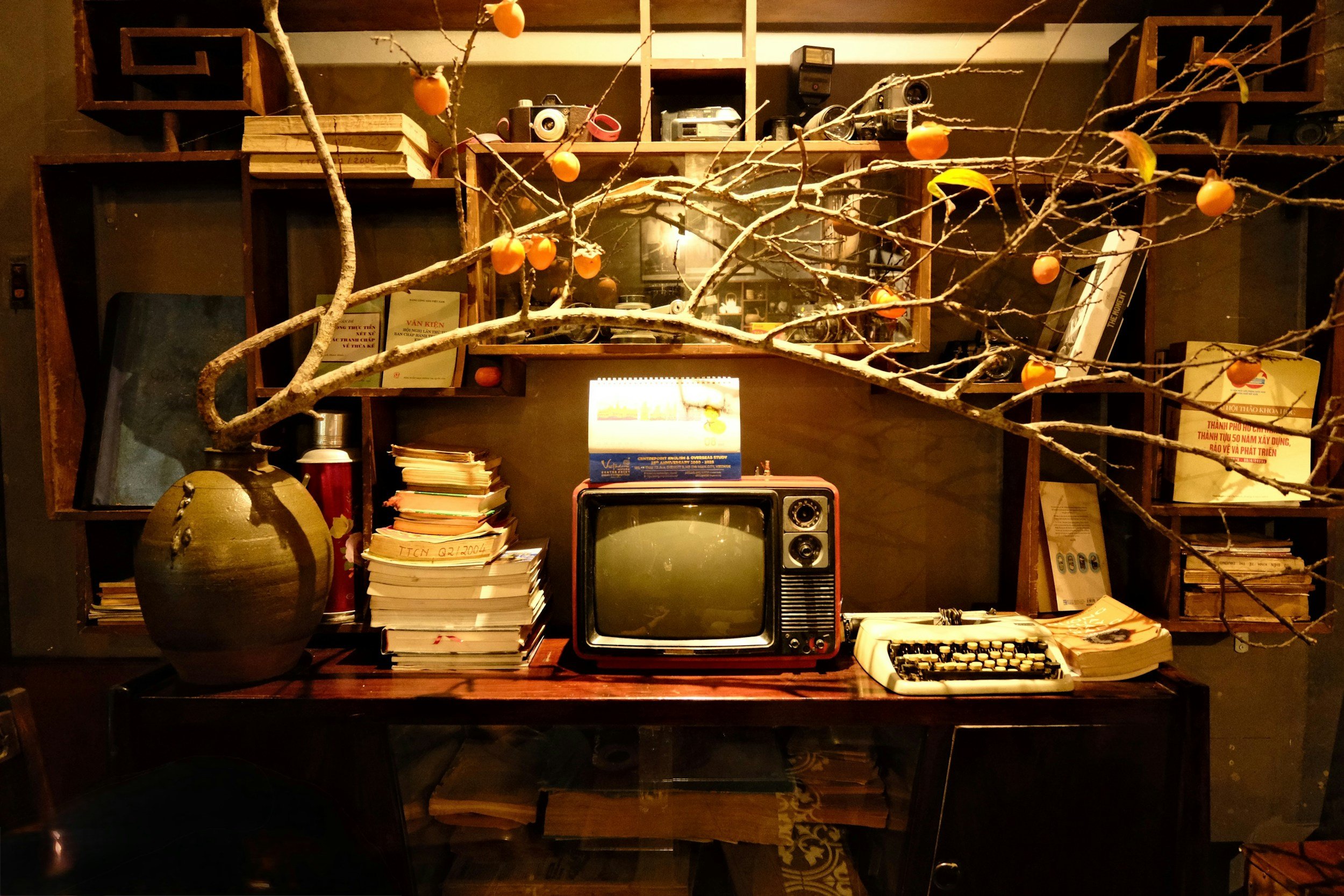 Vintage wooden desk with books, typewriter, and books