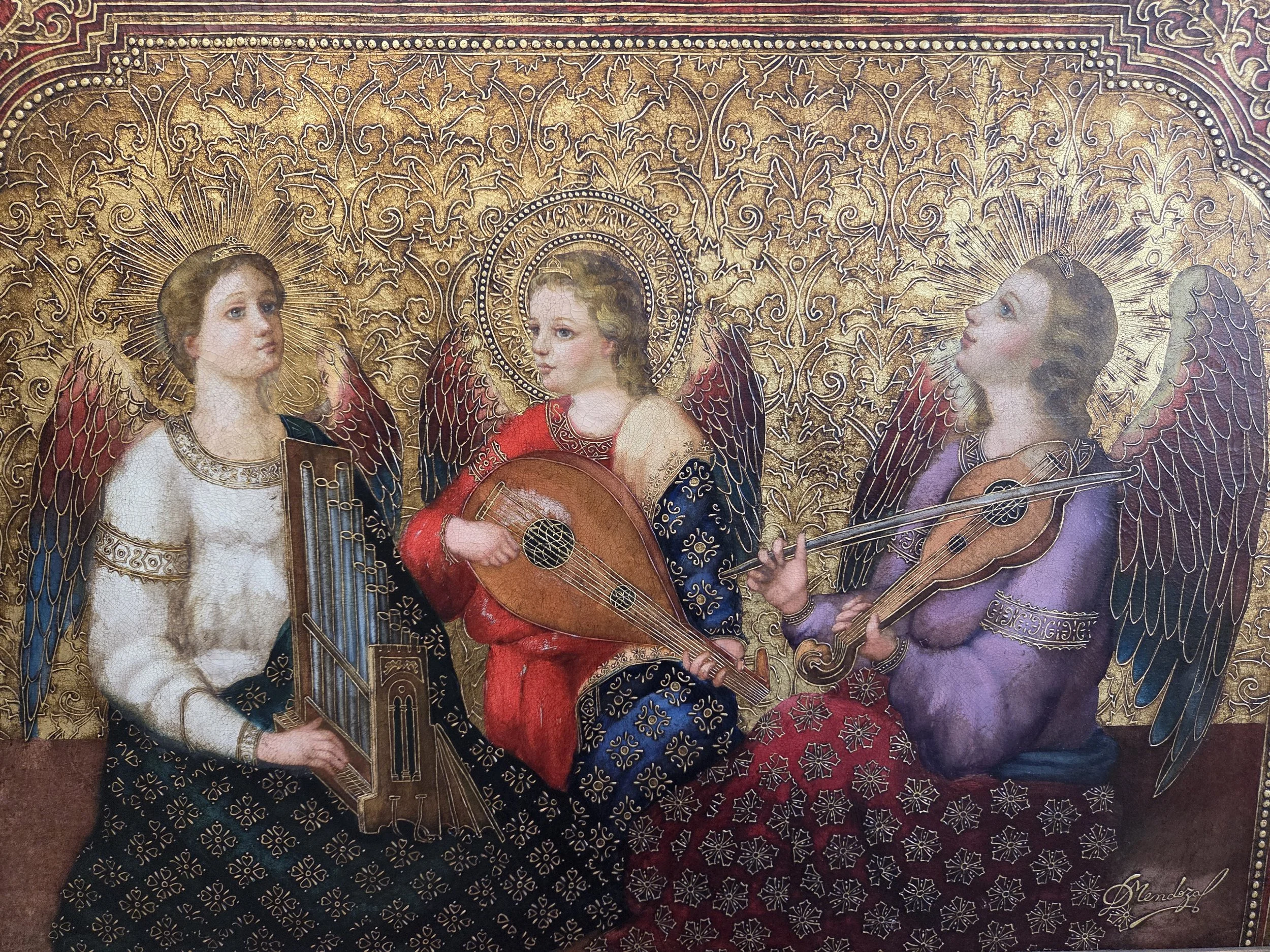 A detailed painting depicting three angels with golden halos and wings, sitting against an ornate gold background. The angels are playing musical instruments: a viol, a lute, and a tambourine.