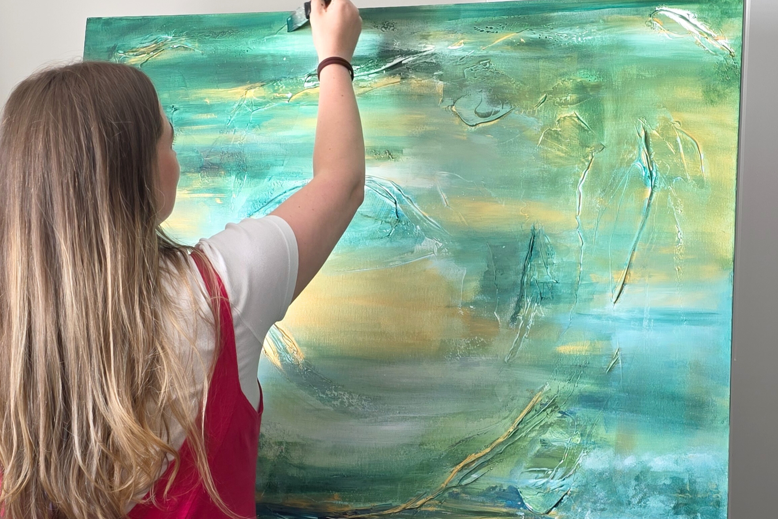 Painting an abstract landscape on a large canvas with green, yellow, white, and teal colours. Luxury Abstract Christian Art Work Original pieces and commissions