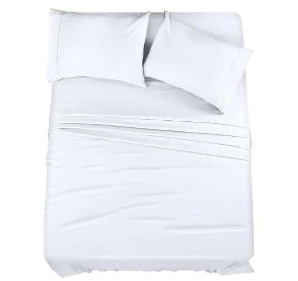 A white bed with two pillows and a fitted sheet.