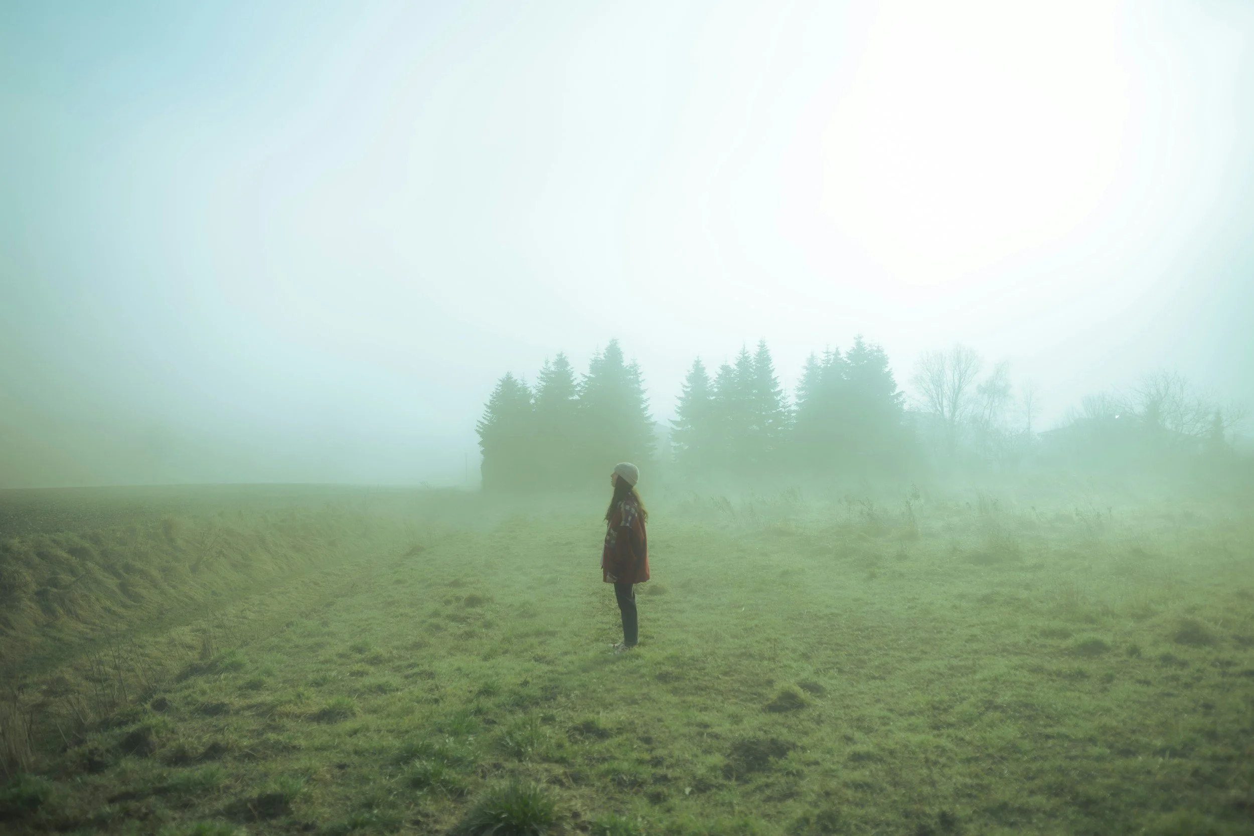 Person standing in the fog, symbolizing the uncertainty and constant vigilance that often accompany anxiety.