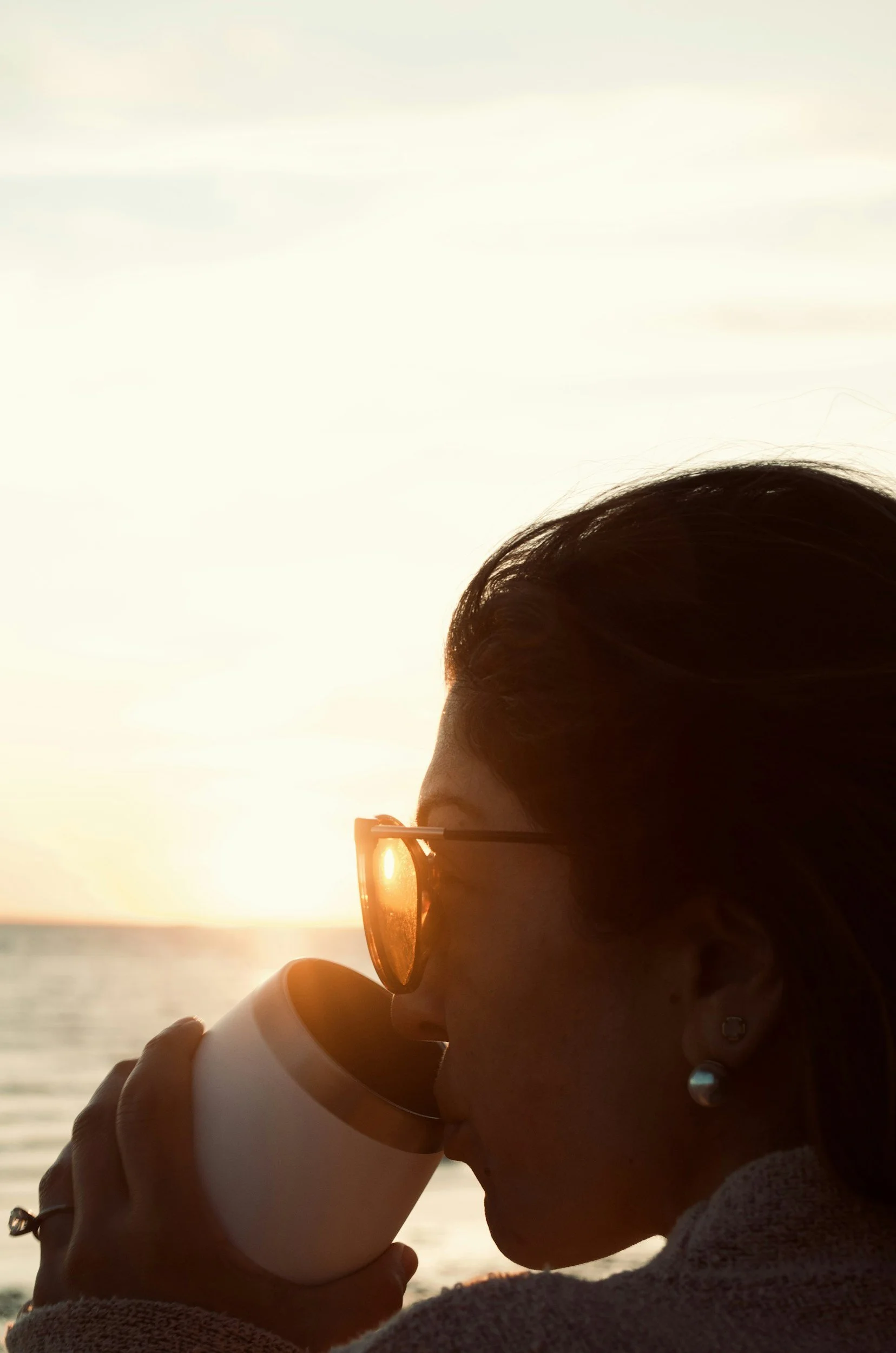 Person enjoying a quiet moment with coffee at sunset, representing the greater sense of calm, presence, and balance that therapy can help cultivate.