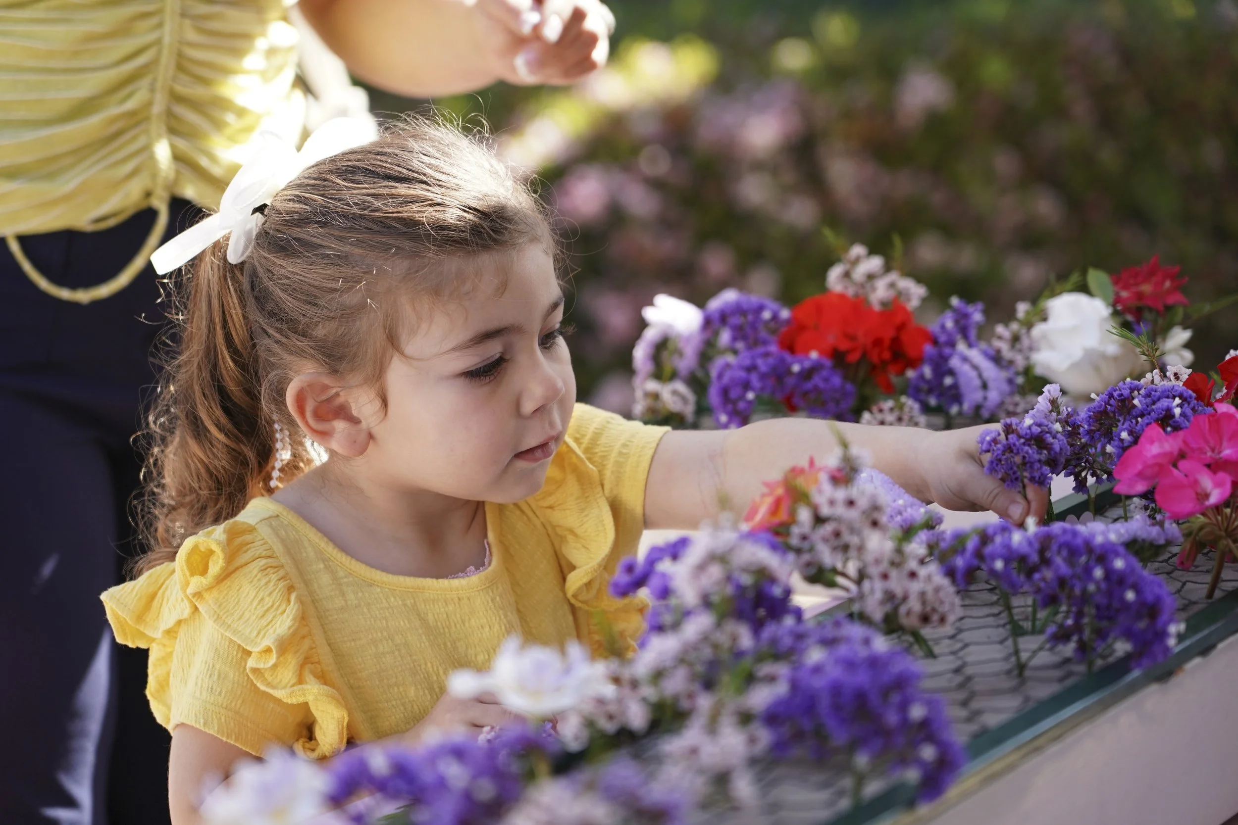 Child puts flowers on a cross. 