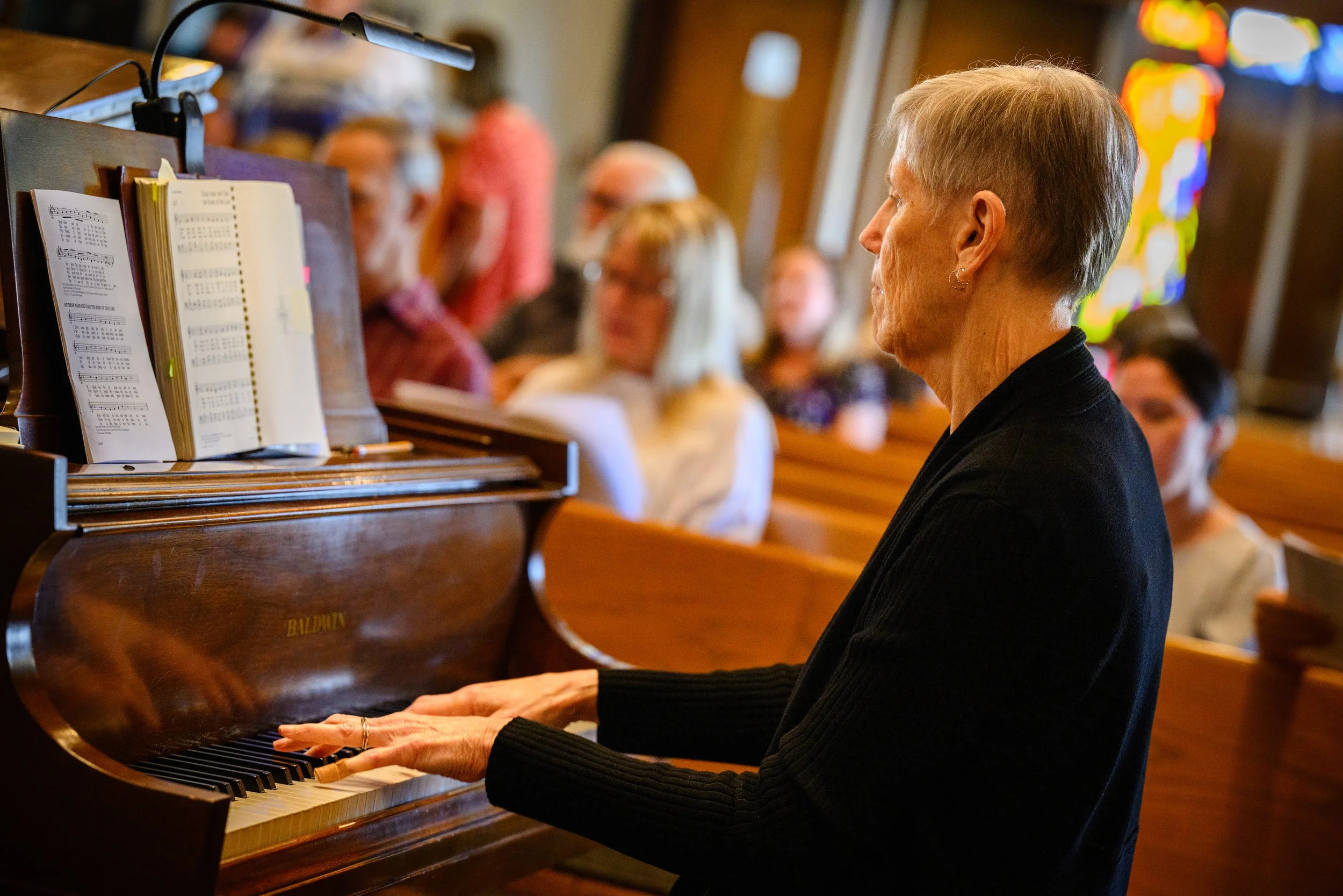 Playing piano with a congregation in the background