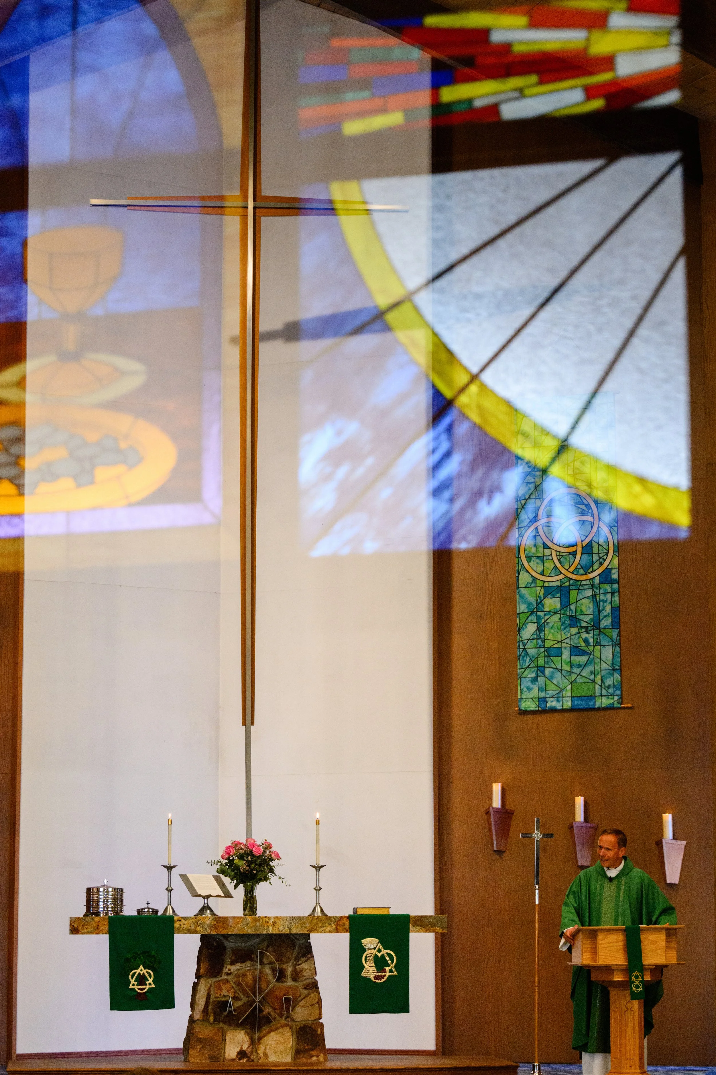 Stained glass appears above the pastor as he preaches