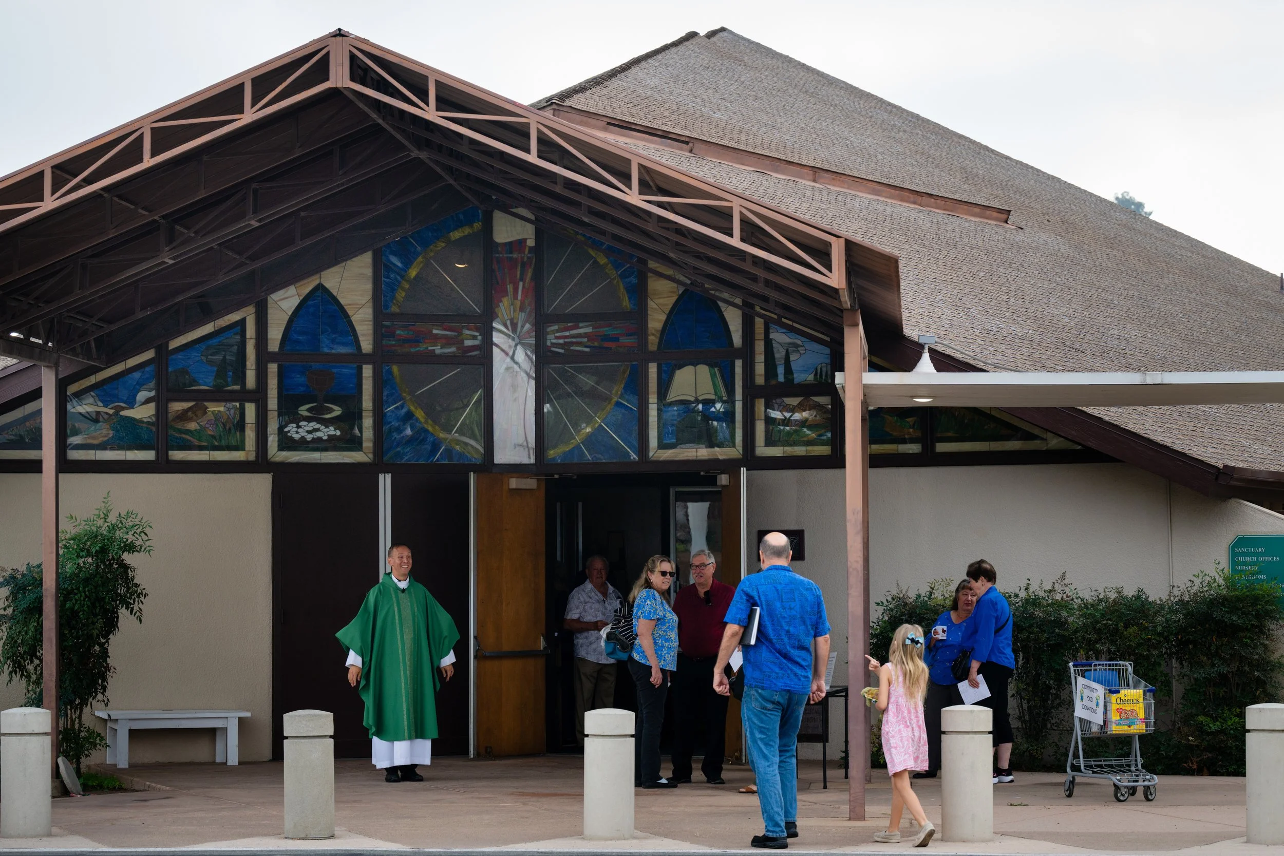 People stand outside a church smiling and greeting each other