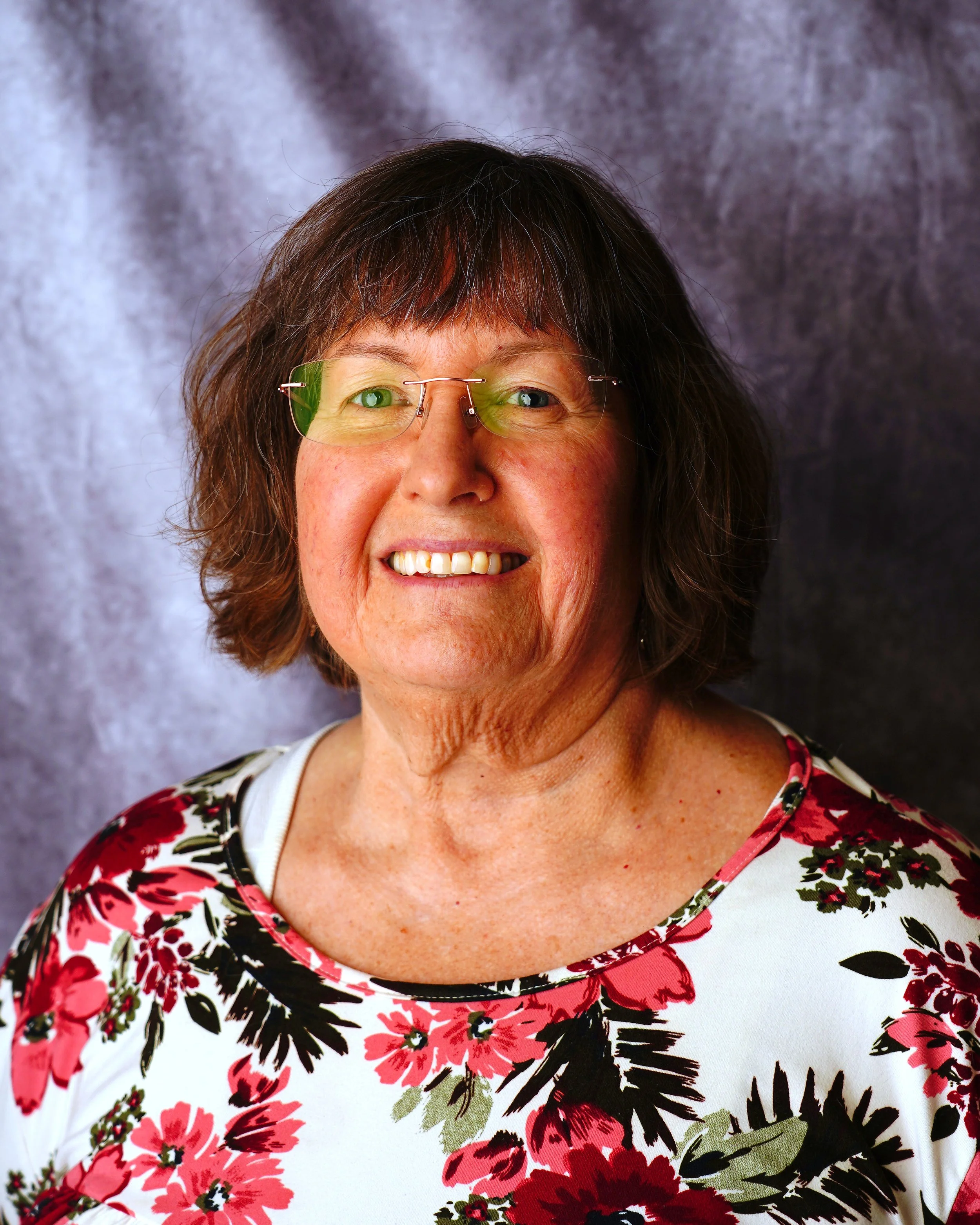 Linda Foltz headshot. Woman with classes and a beautiful smile!
