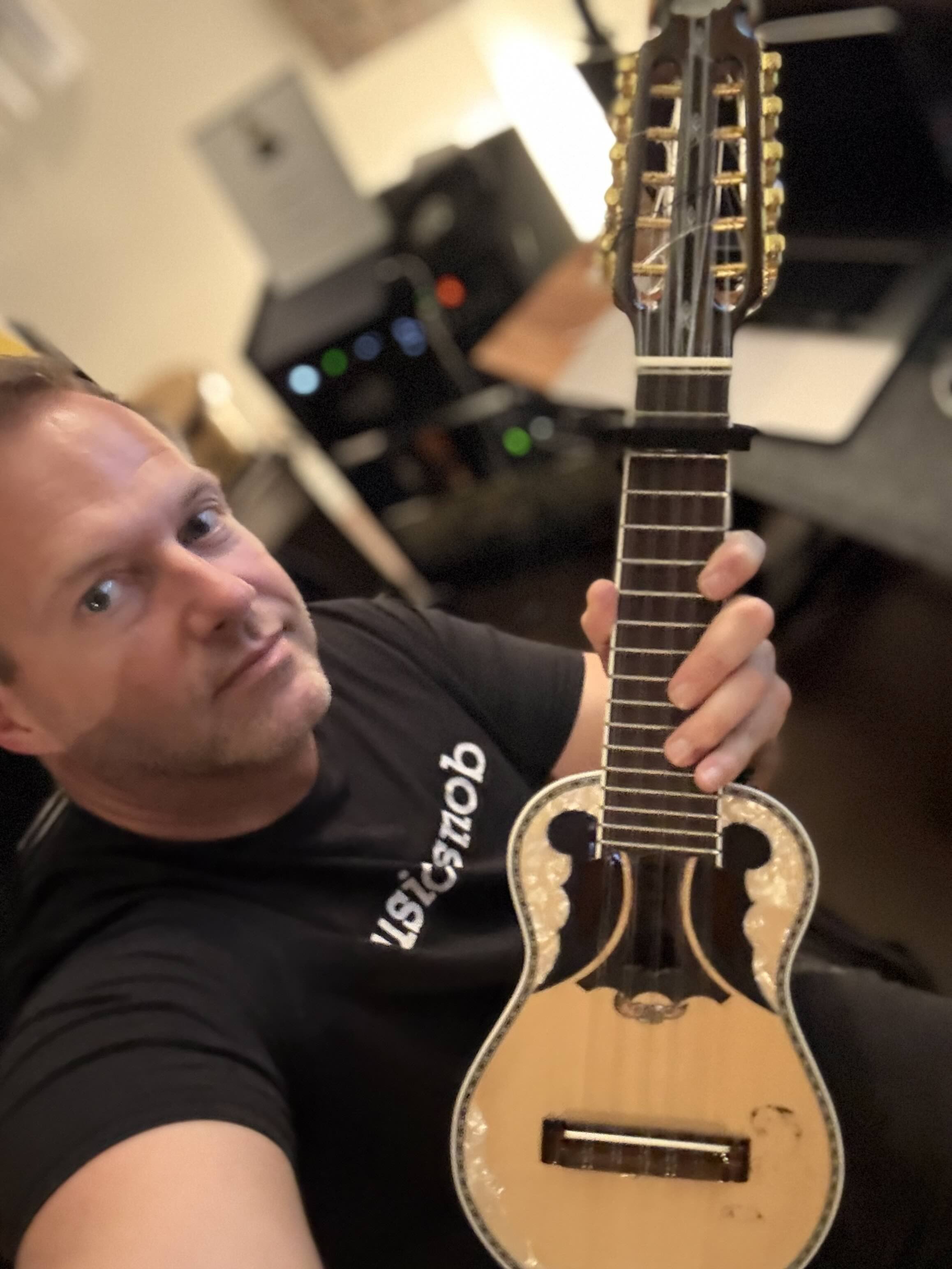 Markus Illko holding up the instrument Charango