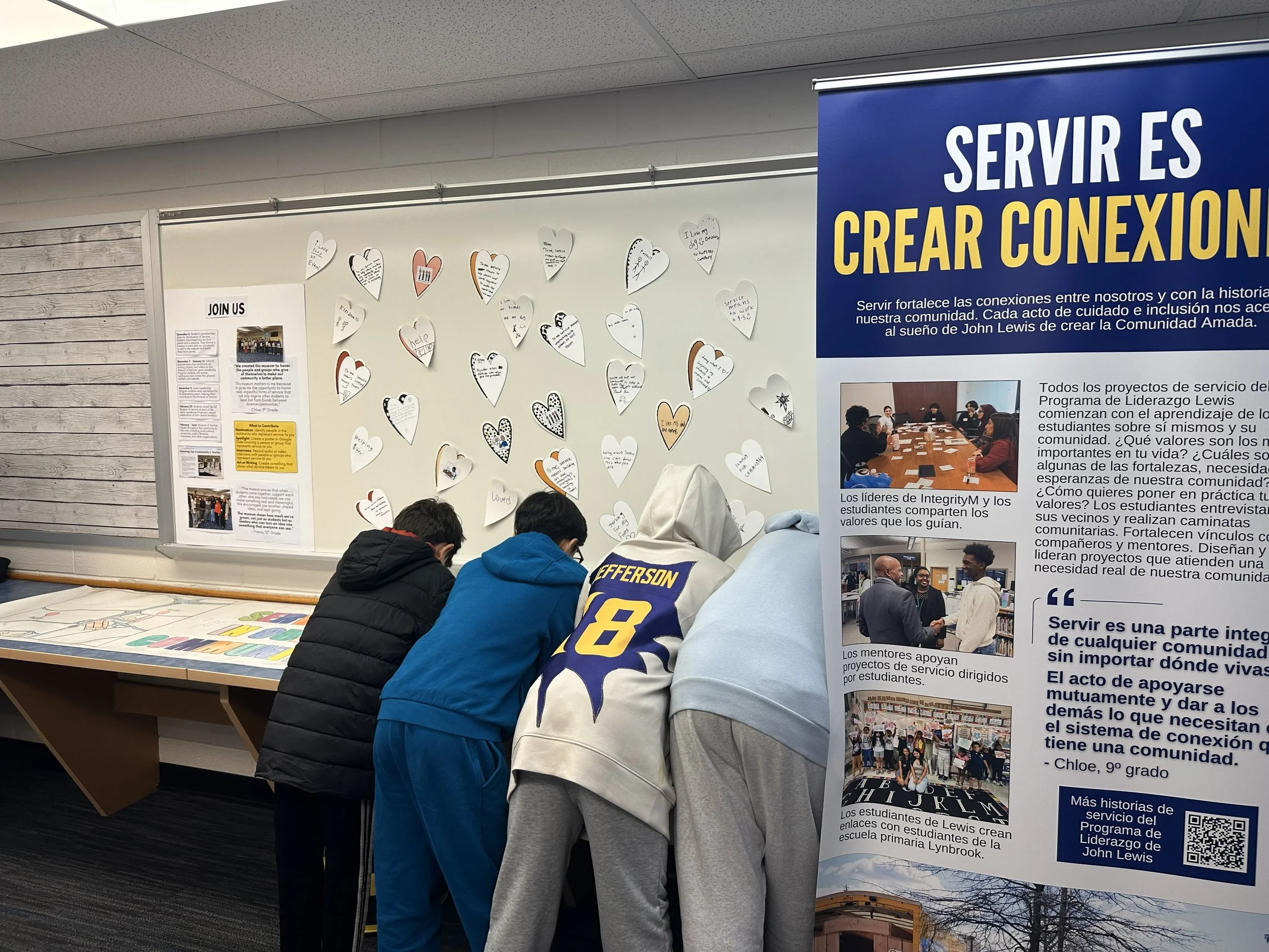  Students contribute messages for the wall of hearts, sharing what service means to them 