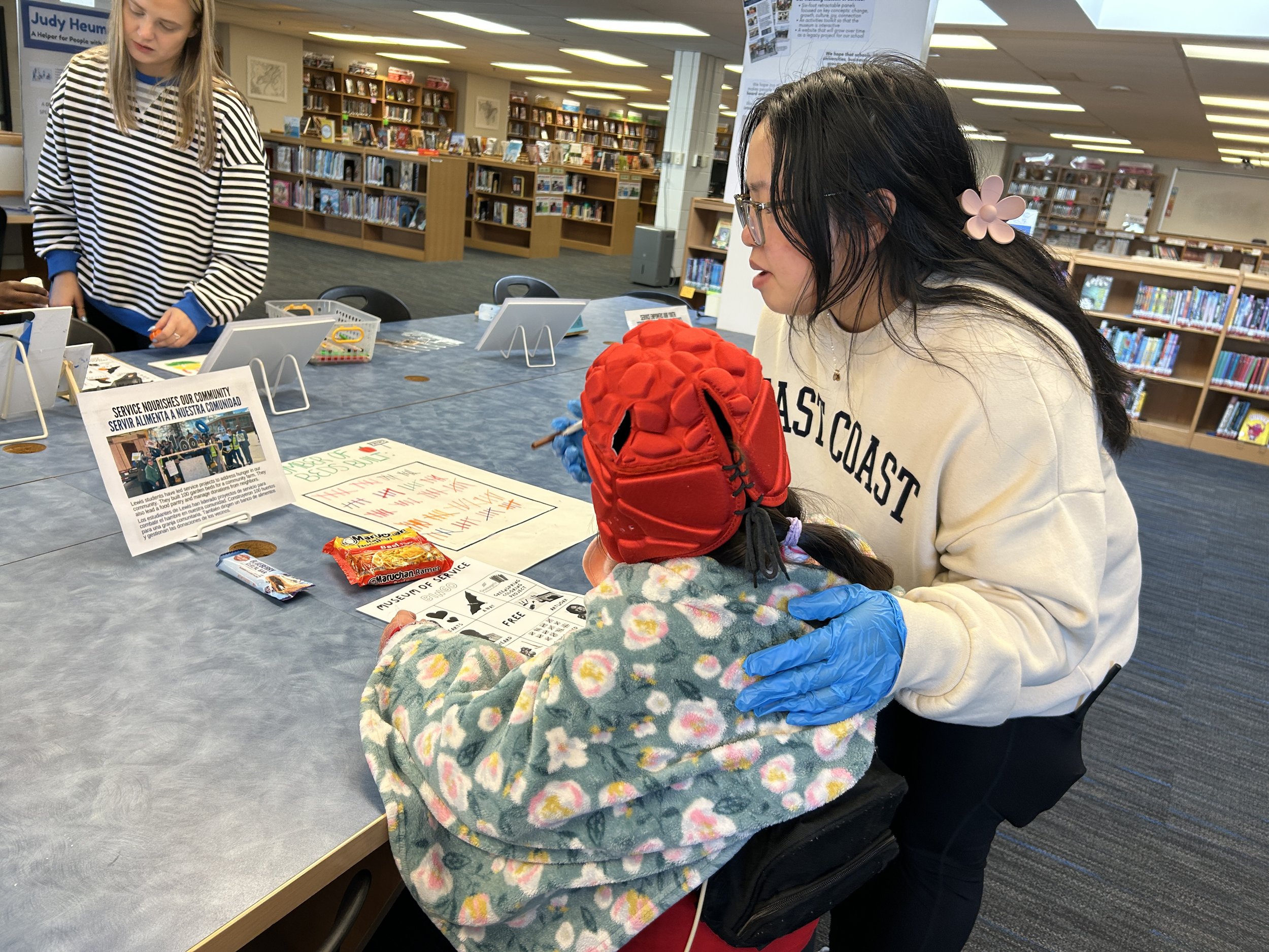  Student and staff member explore an exhibit about Lewis students’ efforts to address hunger in the community 
