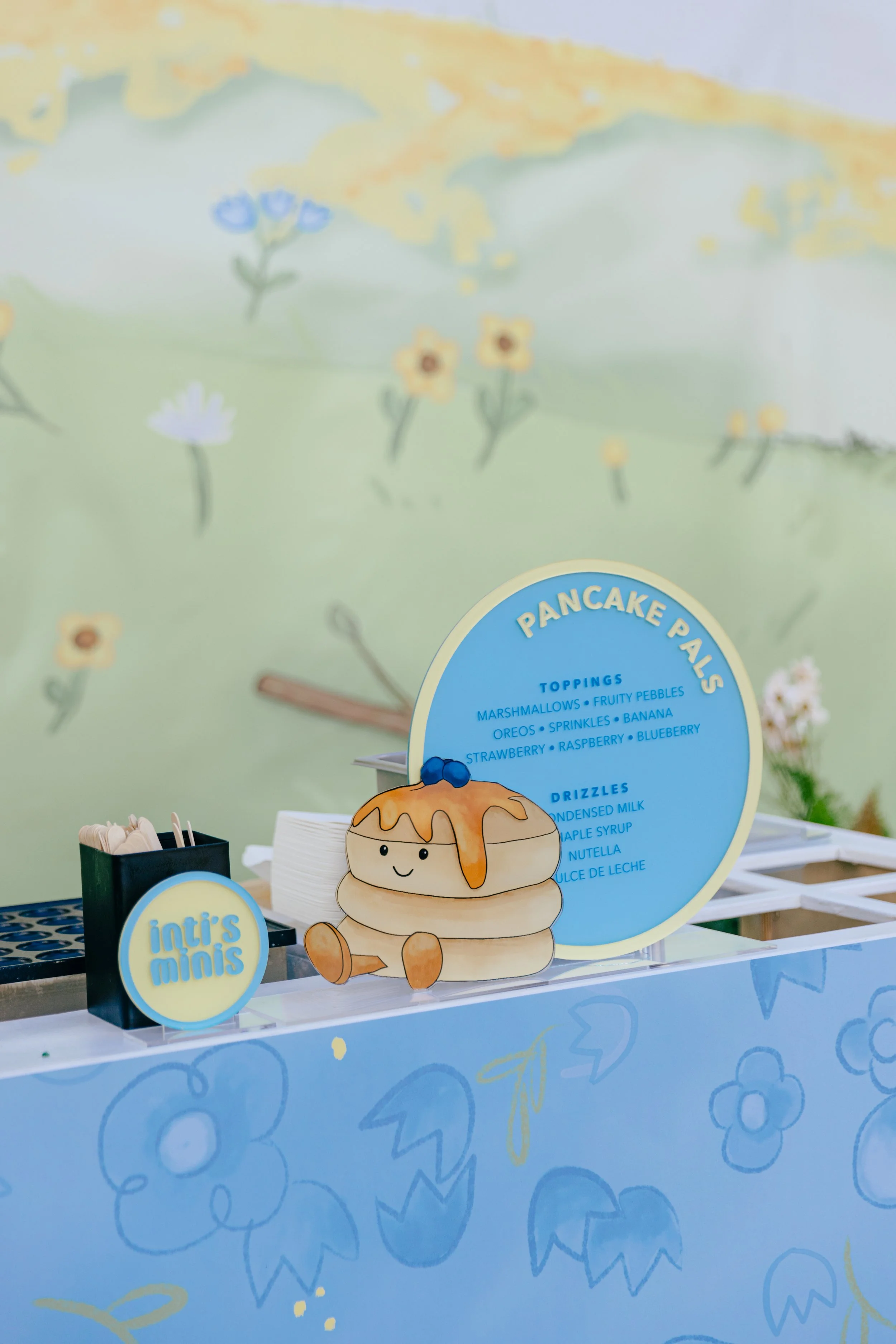 A pastel-colored backdrop, table top sign, table signage, custom signage, custom food menu signage, custom food menu