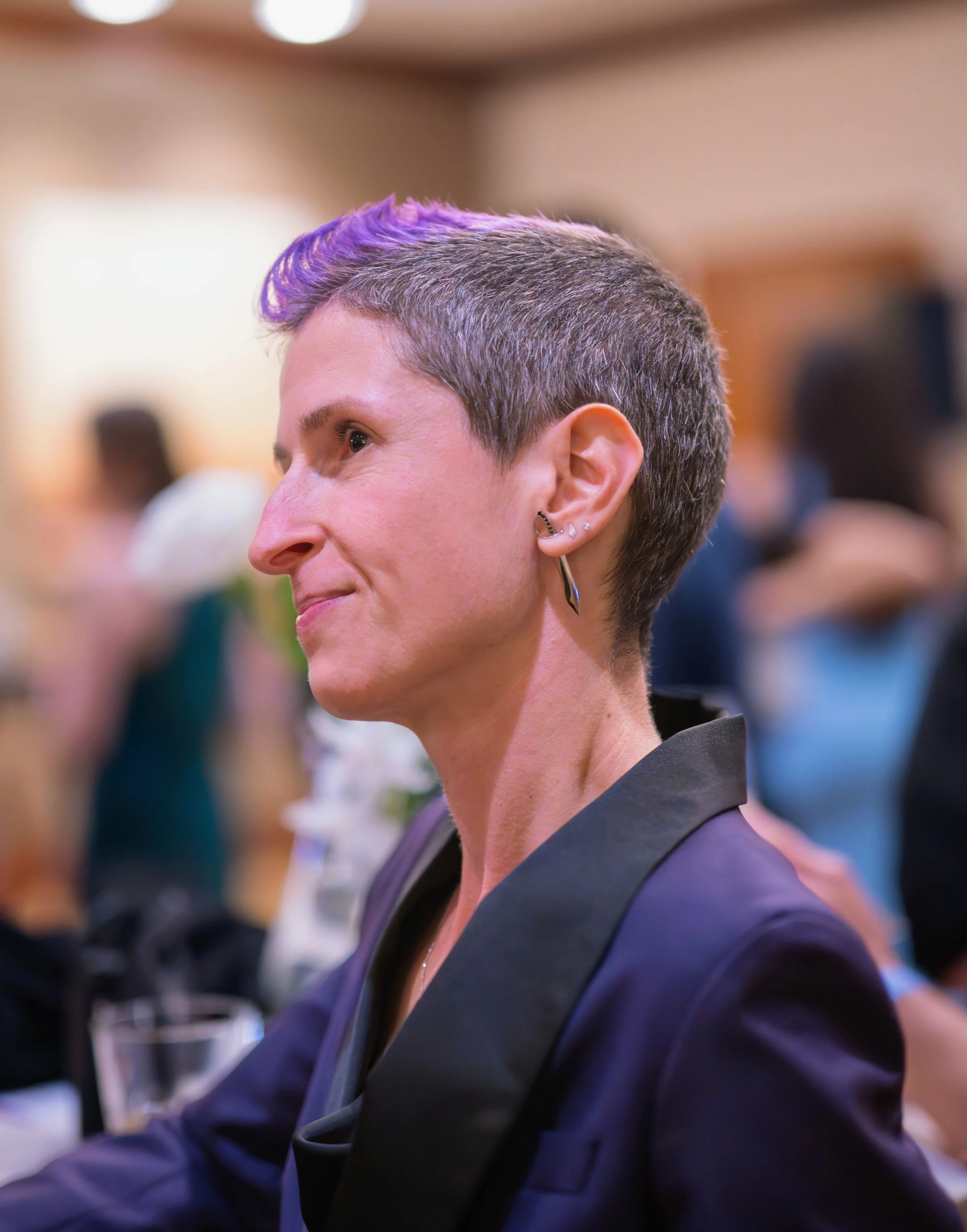 woman in tux with short hair and purple mohawk