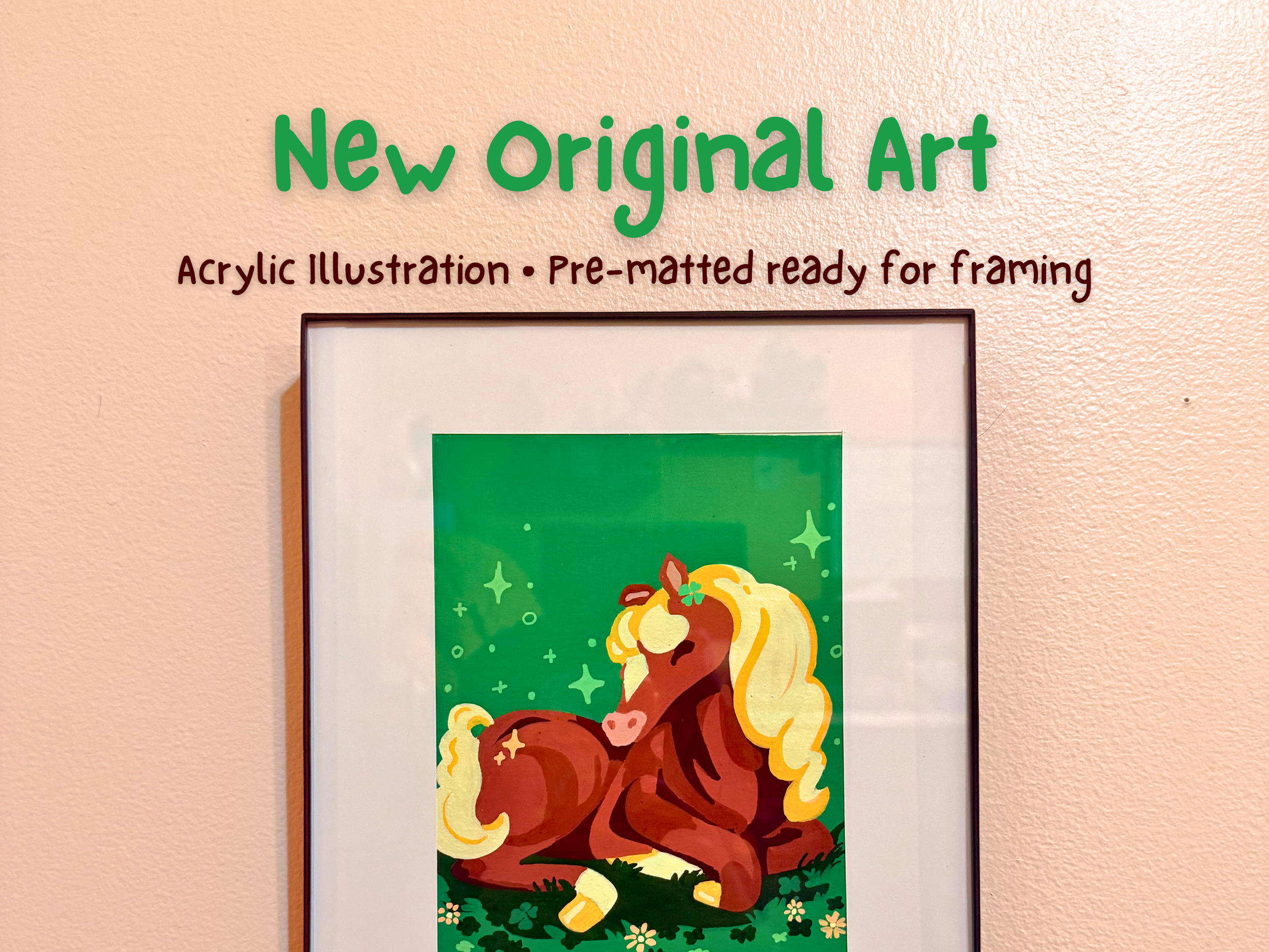 A framed acrylic illustration of a brown horse with a yellow mane, sitting on green grass with small white flowers, against a green background with star-like sparkles.