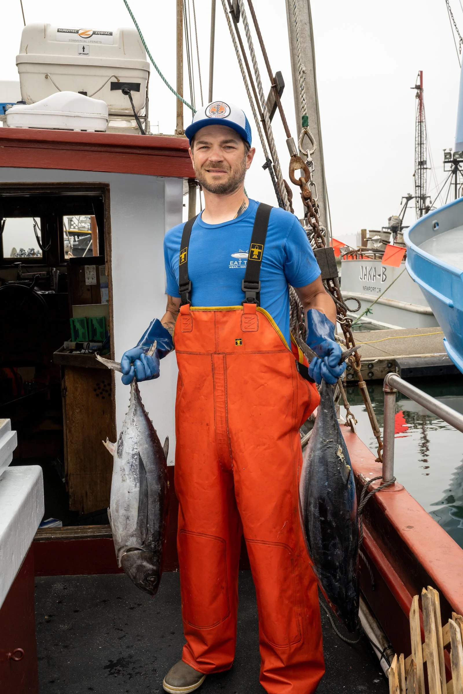 fisherman holding tuna on a fishing vessel