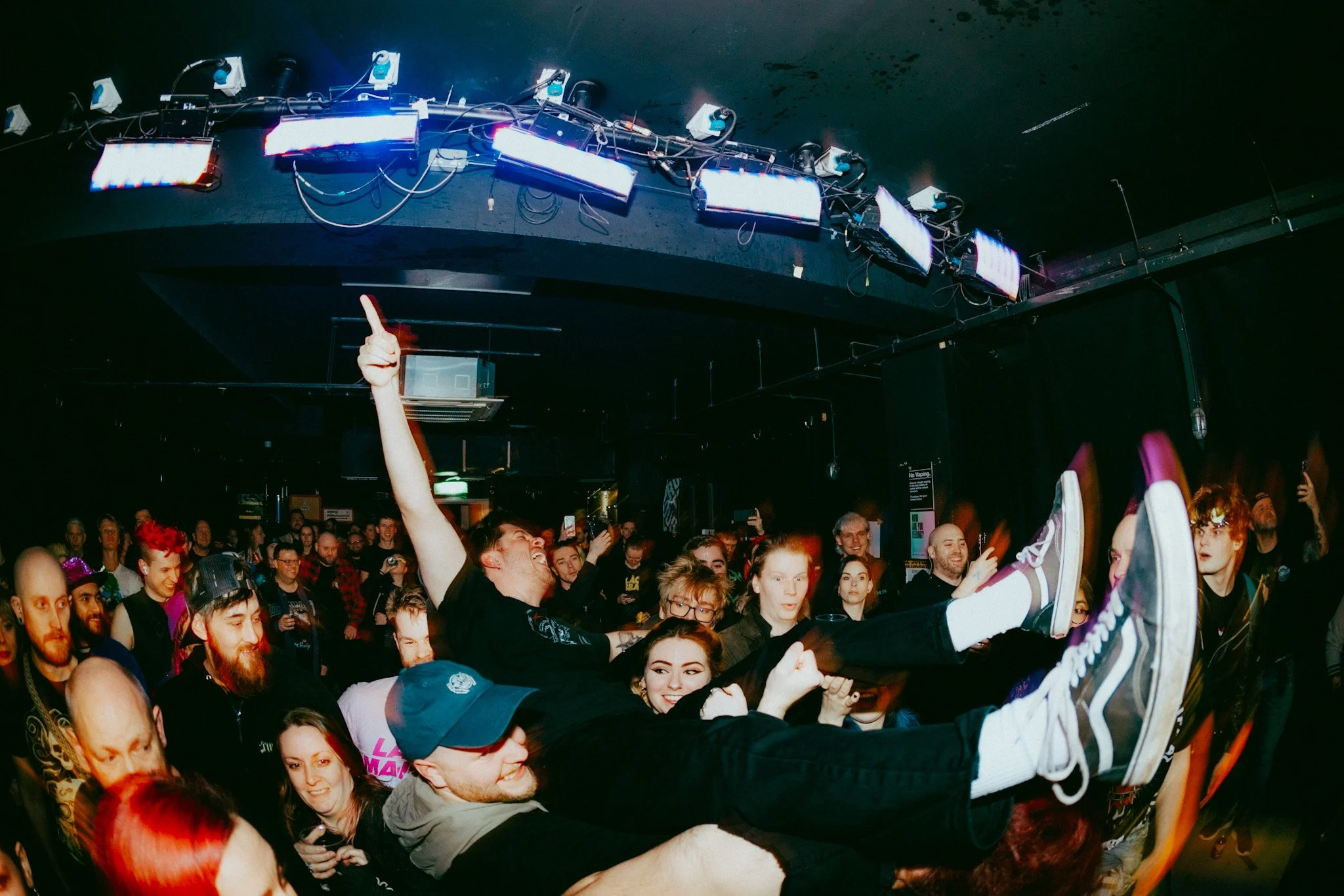 Crowd at a concert or music event with people dancing and enjoying the show.