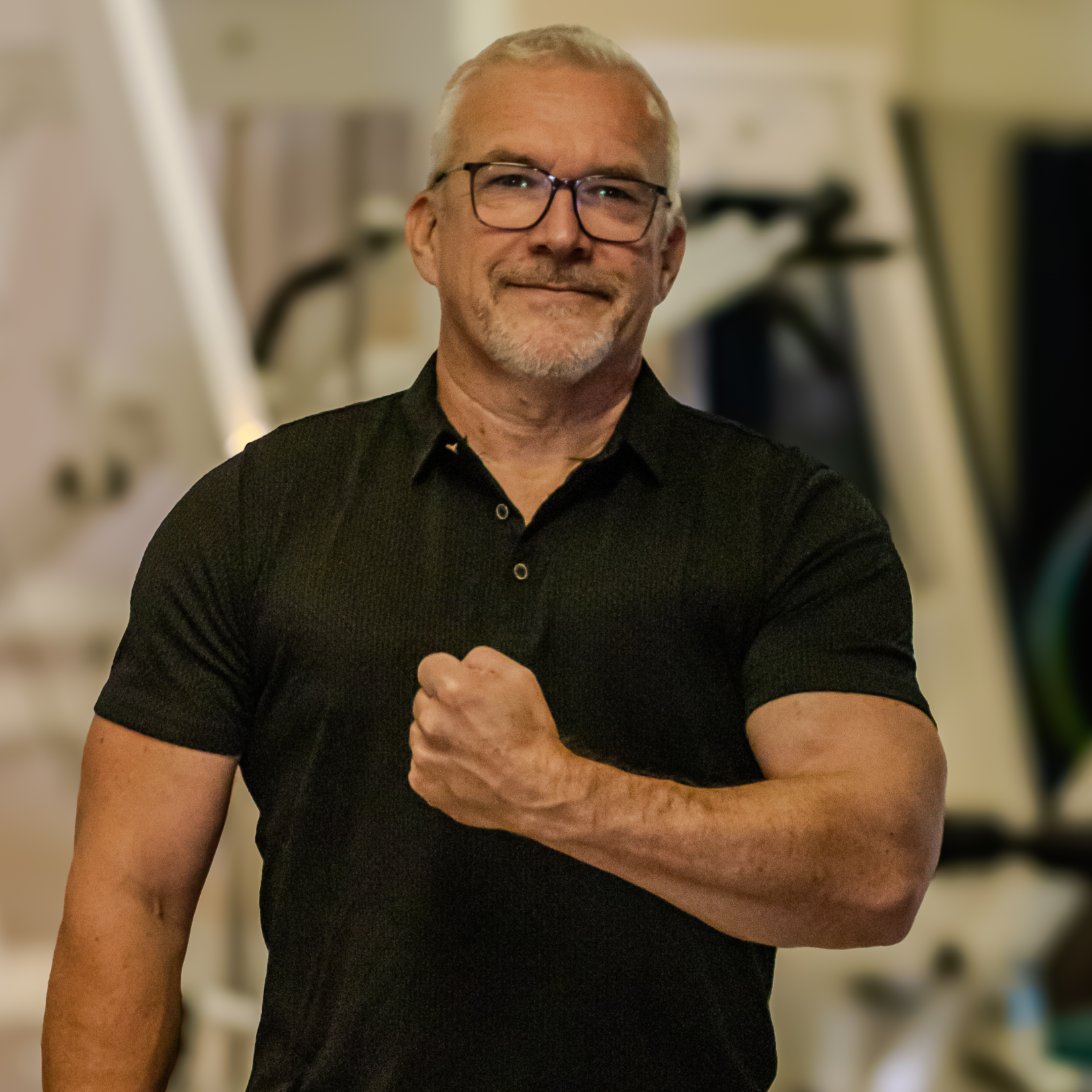 Ein älterer Mann mit Brille, trägt ein schwarzes Polo-Shirt.