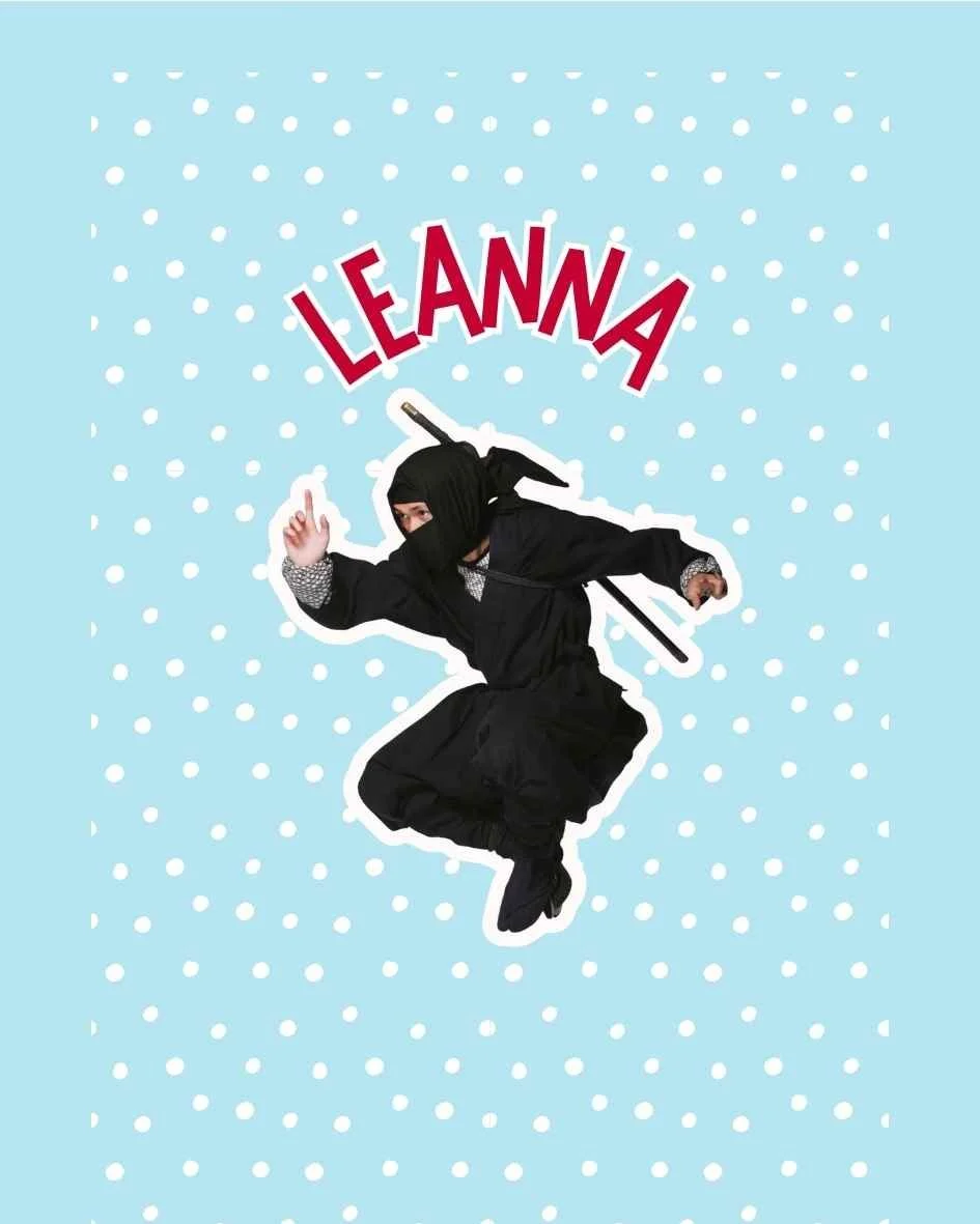 Cover of a book titled 'LEAANNA: Important Elf in the Shadows.' It features a person dressed as a ninja elf in black, crouching, with a snowy background.