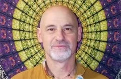 Retrato de un hombre con barba, en un fondo colorido y circular que parece de mandala.