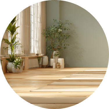 A bright living room with large windows, green plants, a wooden floor, and minimalist decor.