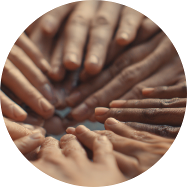Multiple hands of different skin tones joined together in a circle.