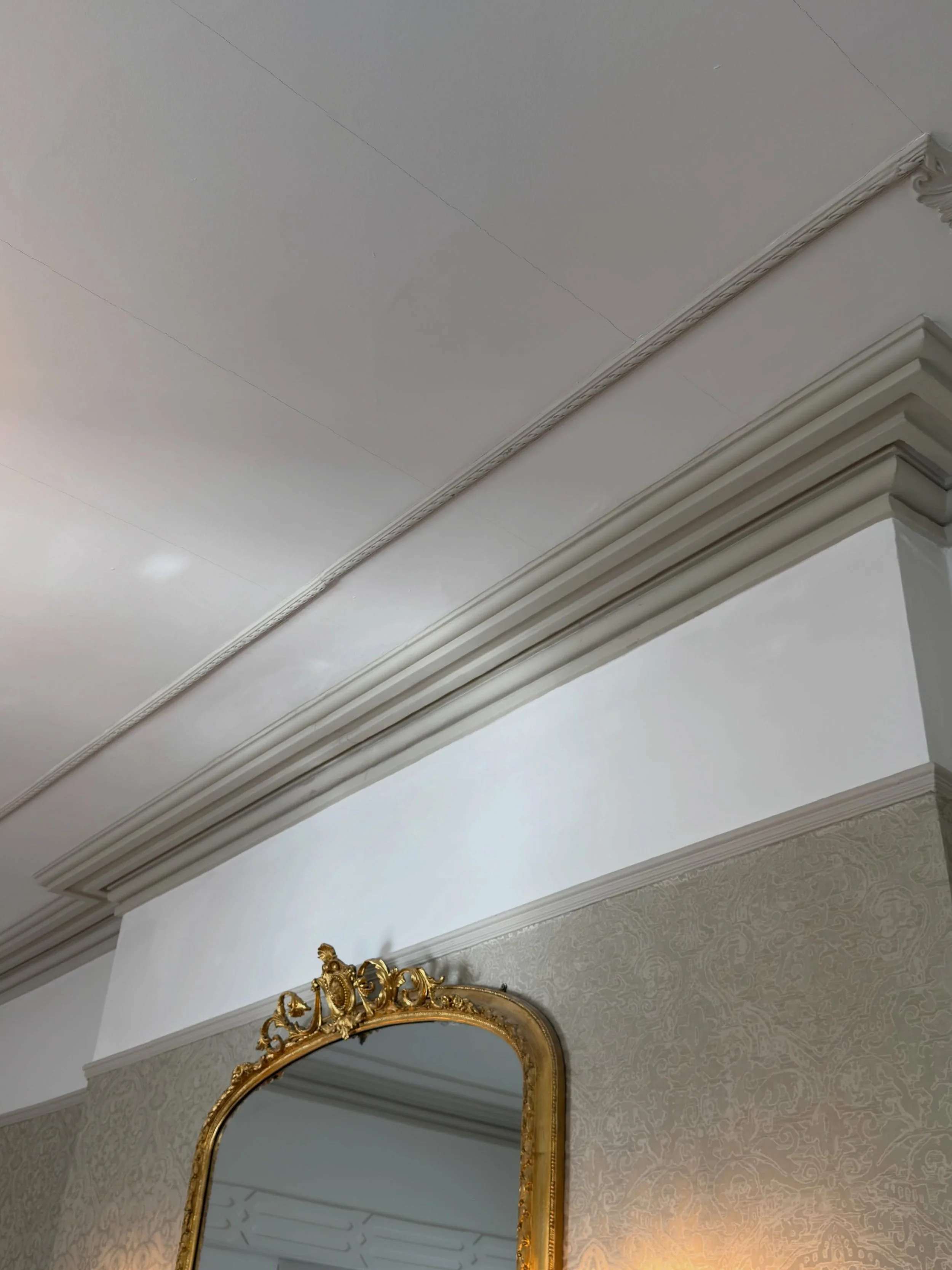 This ceiling coving had been badly affected by a roof leak, with cracks, damage and peeling paint visible throughout. After careful repairs, preparation and repainting, it&rsquo;s finally been brought back to life &mdash; finished in the same origina