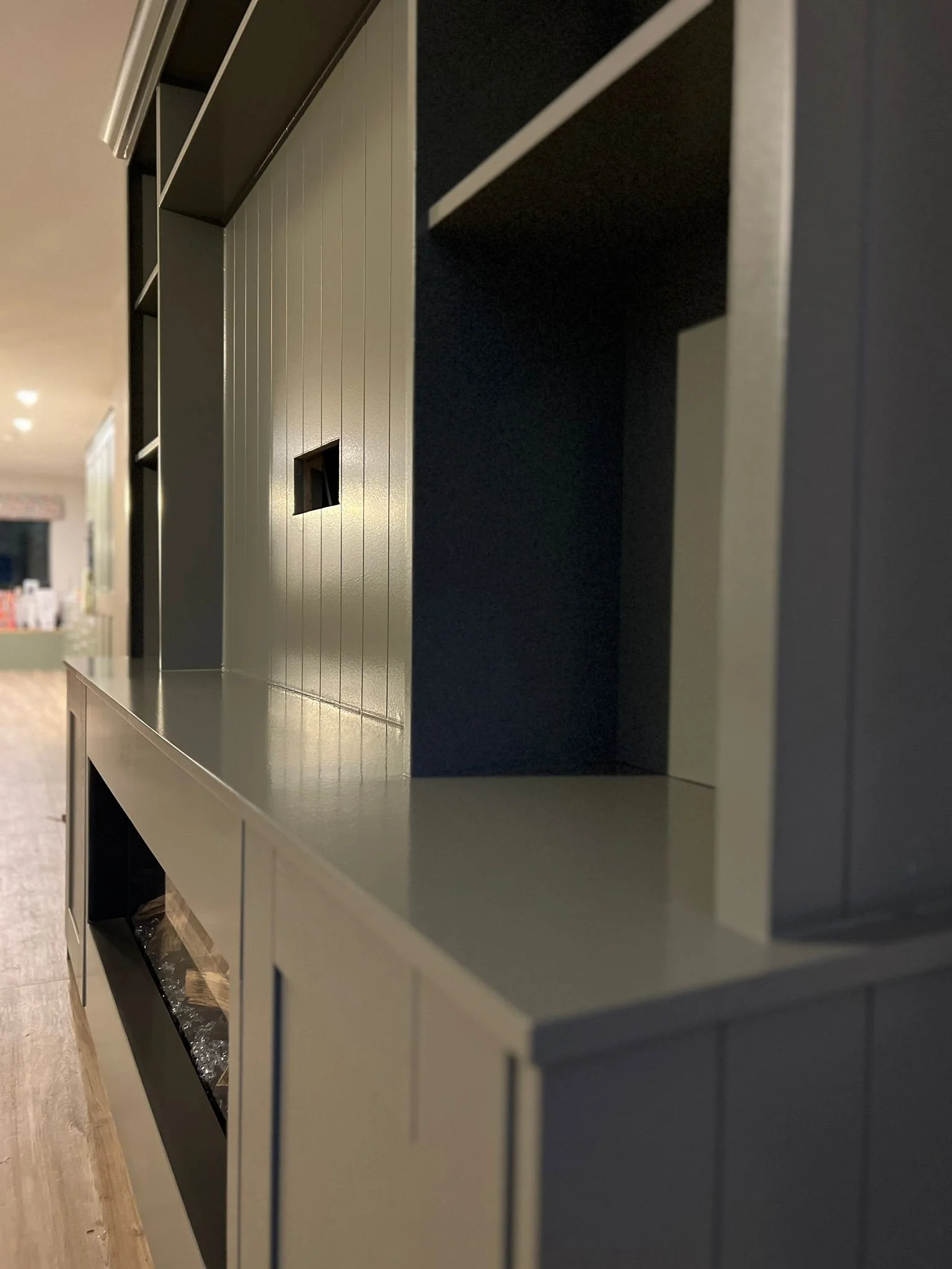Close-up of a modern kitchen cabinet with open shelves and a countertop.