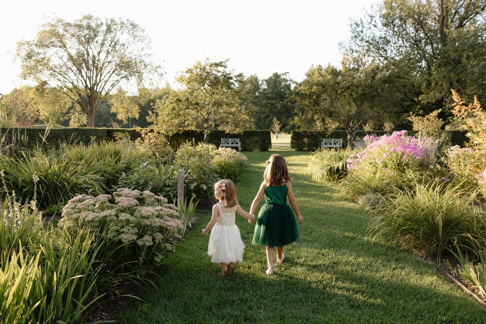 Two girls walking in a garden