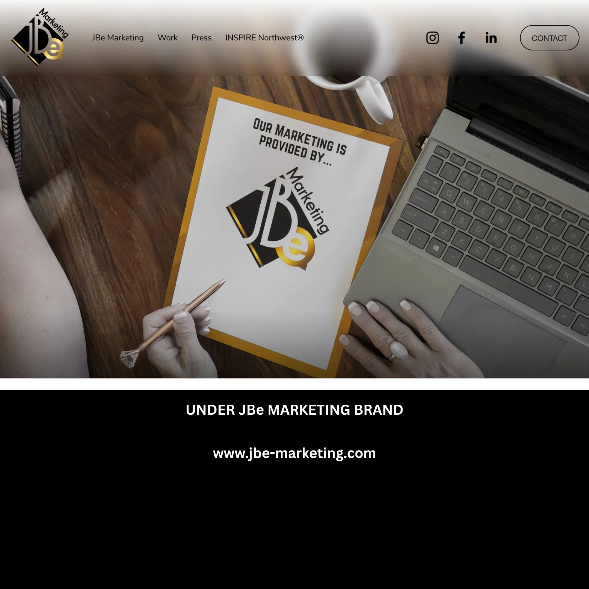 A desk with a person holding a pen, a laptop, a coffee mug, and a printed sheet with JBe Marketing logo and text.