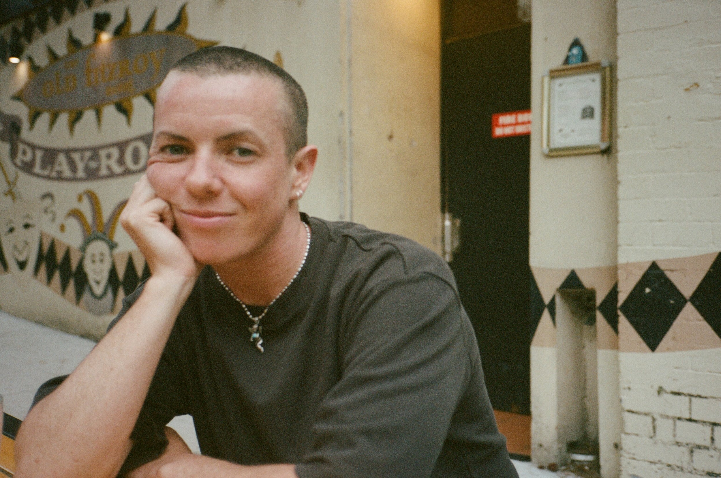 A smiling Dylin Hardcastle resting his head on his hand.