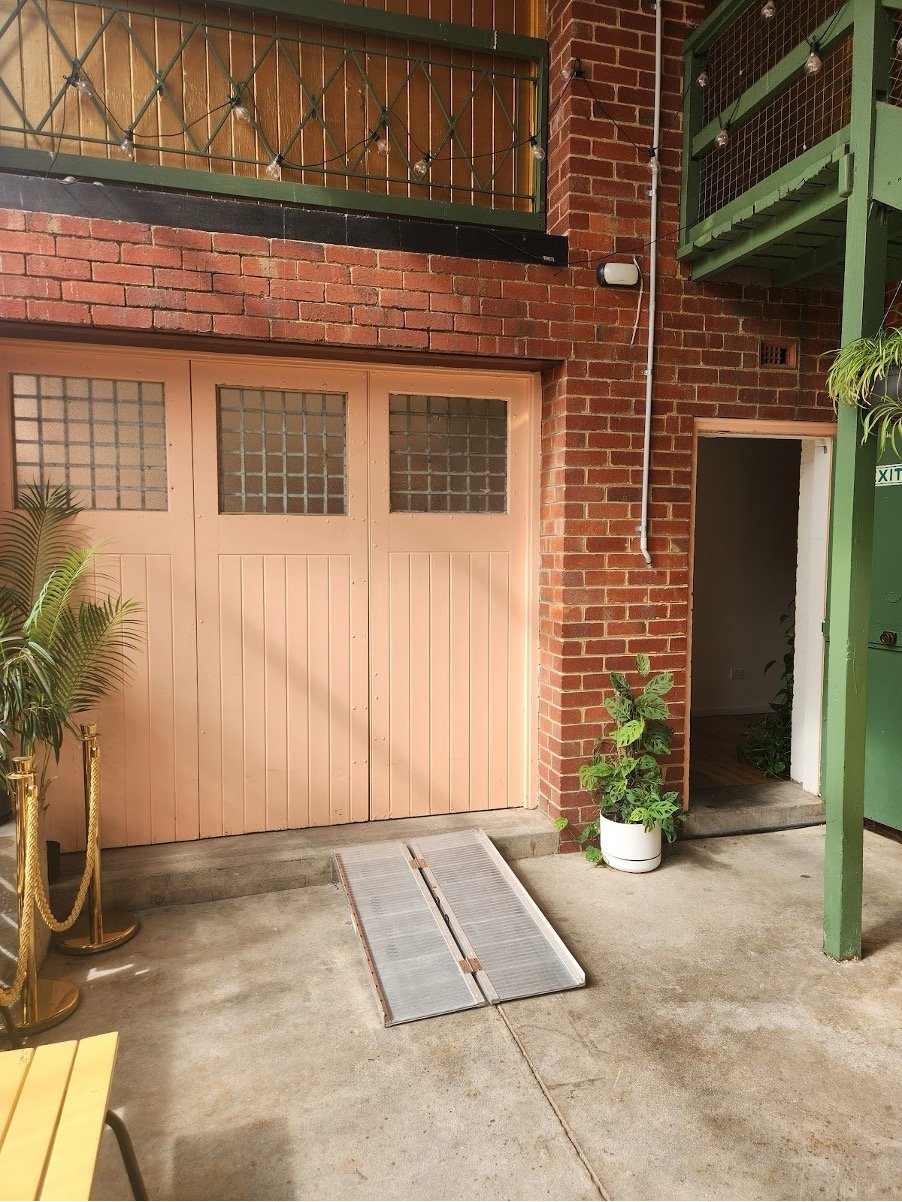 The side entrance of Studio Take Care, which has double doors accessible by a ramp