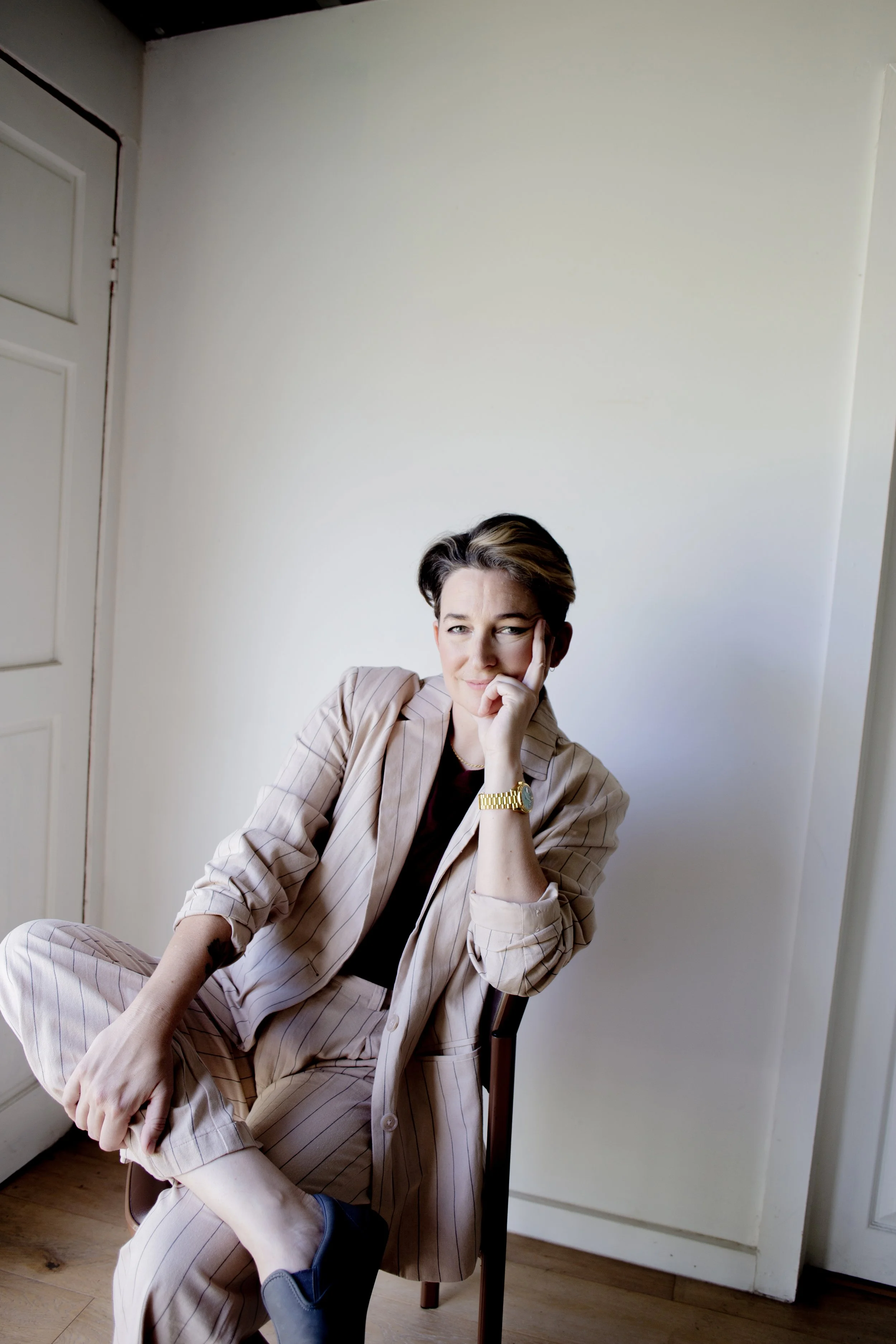 A smiling Clem Bastow lounging in a chair.