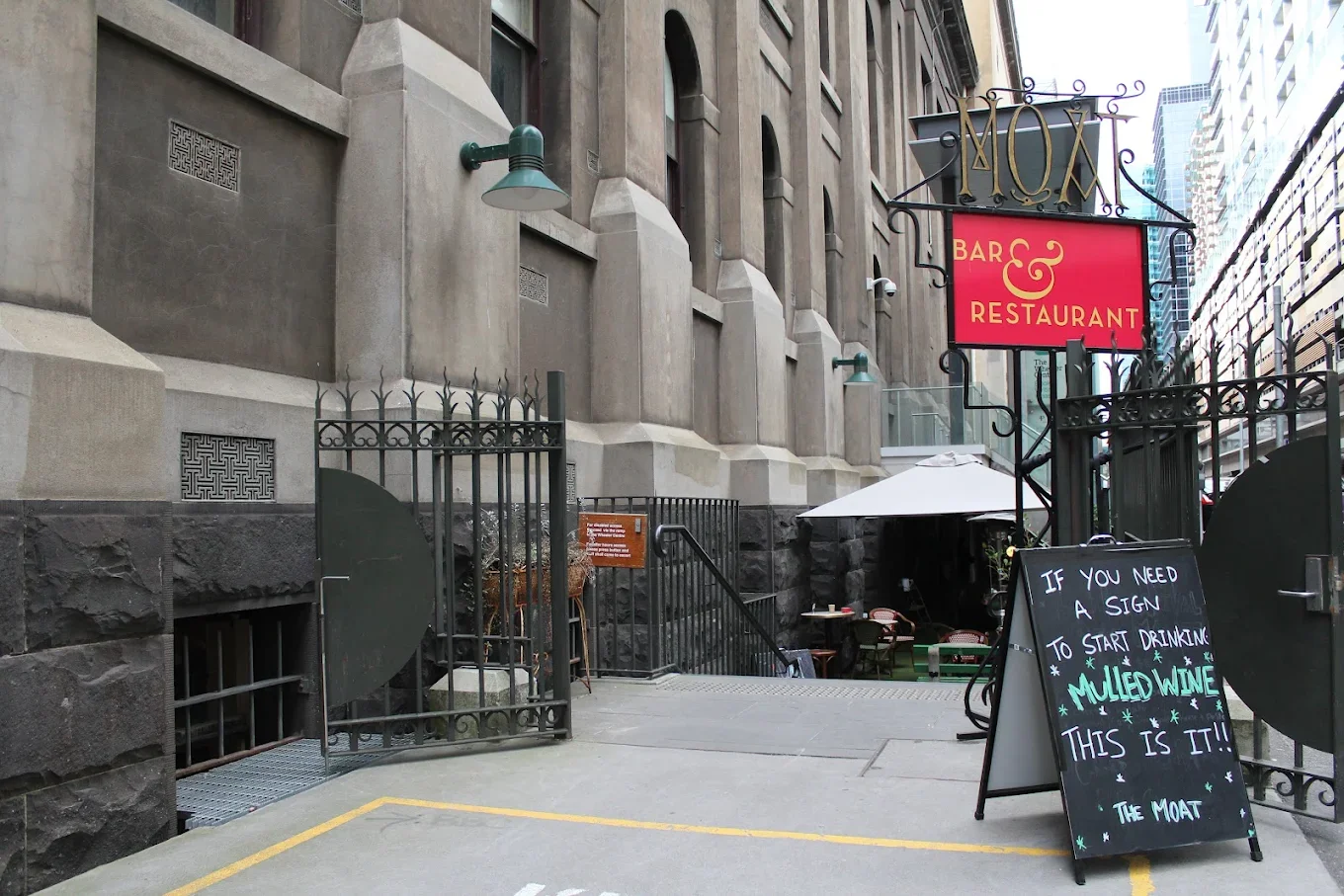 A gated entrance to stairs that lead down to the restaurant The Moat