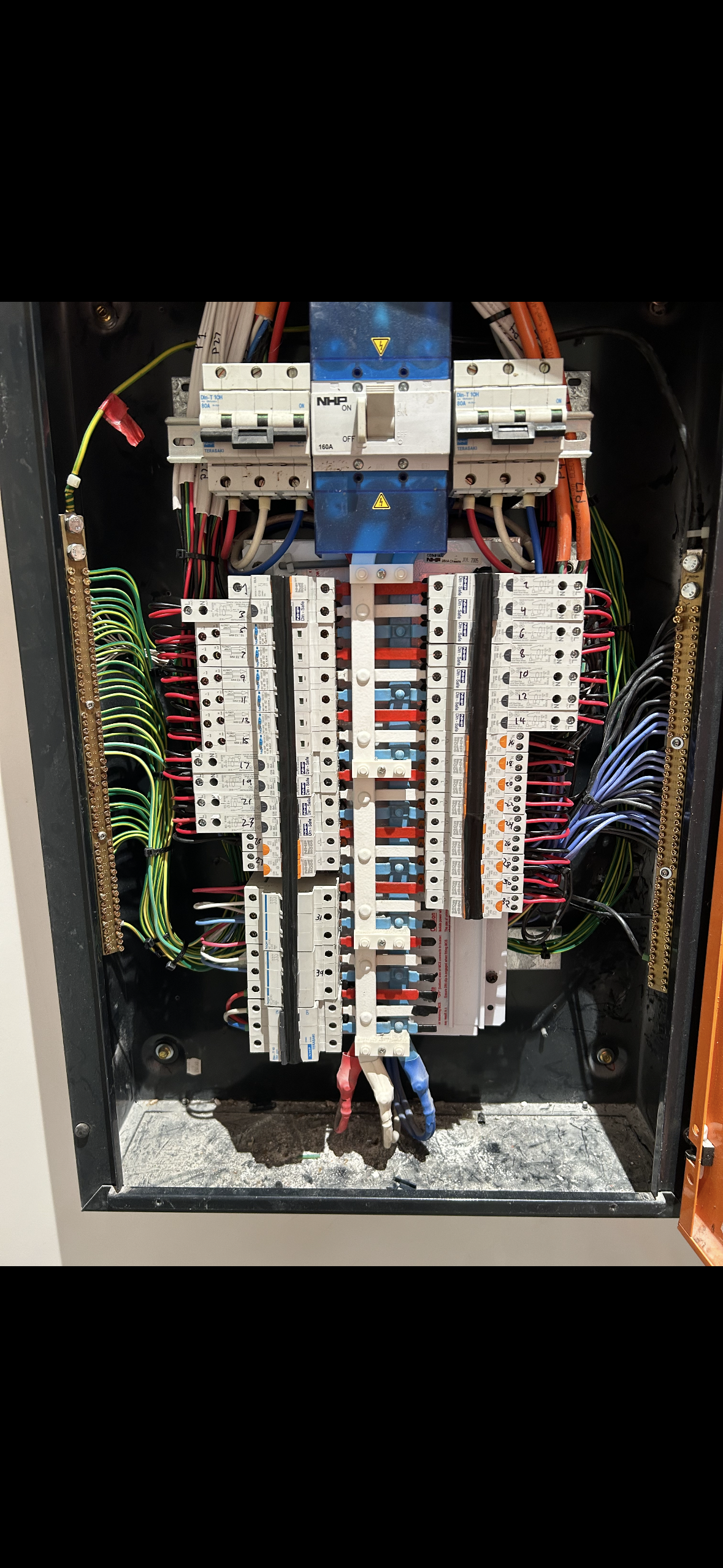 An electrical control panel with various colored wires, switches, and circuit breakers.