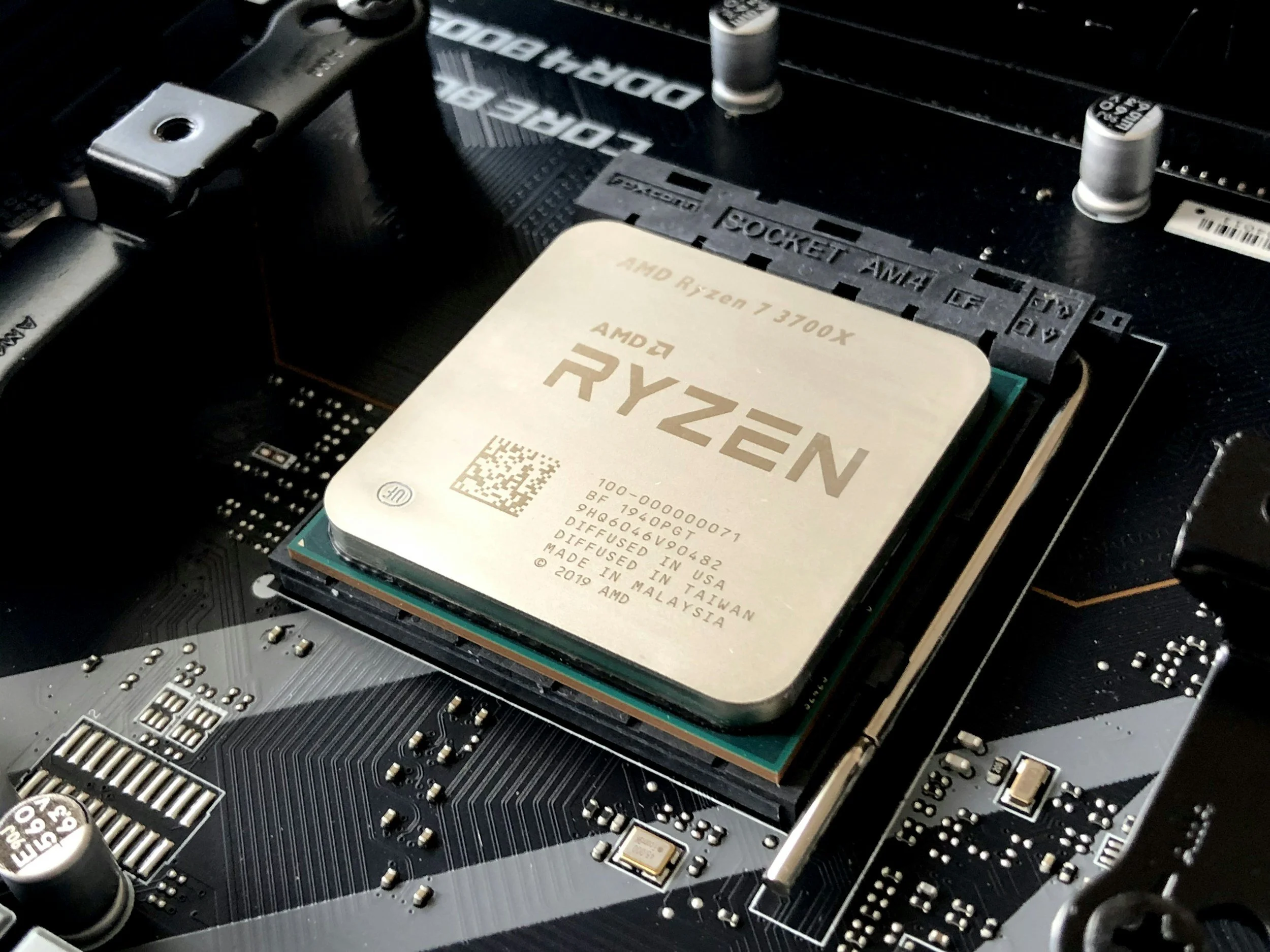 Close-up of a computer motherboard with an AMD Ryzen 7 3700X processor installed in the socket.