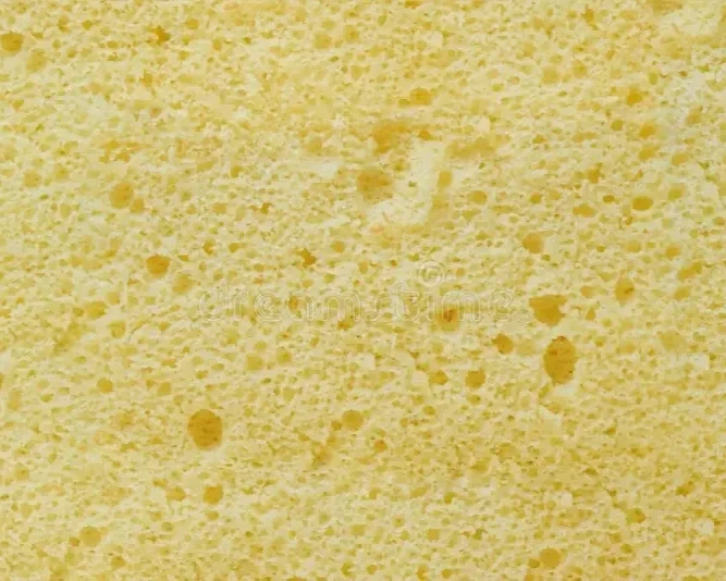 Close-up of a yellow kitchen sponge with a porous surface.